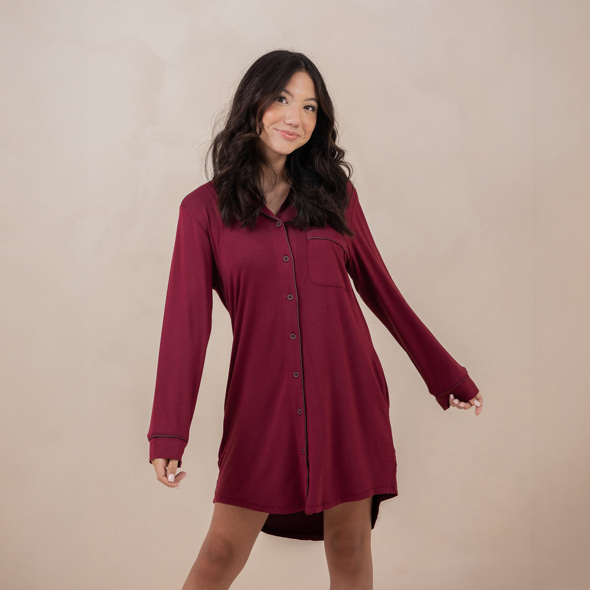 Female models standing with her arms out wearing the Long Sleeve Women’s Nightshirt in Burgundy