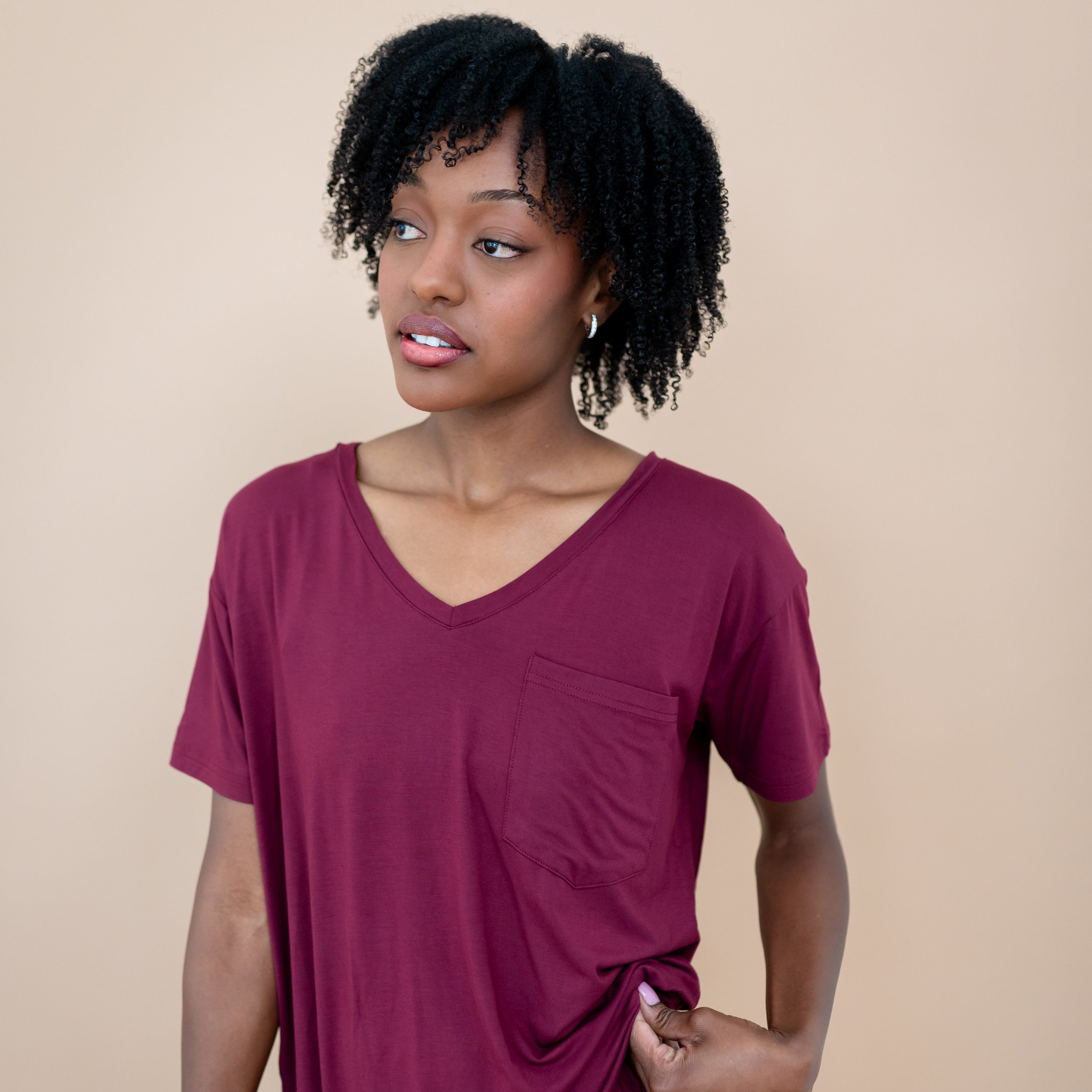 Female looking off to the side wearing the Women’s Relaxed Fit V-Neck in Burgundy