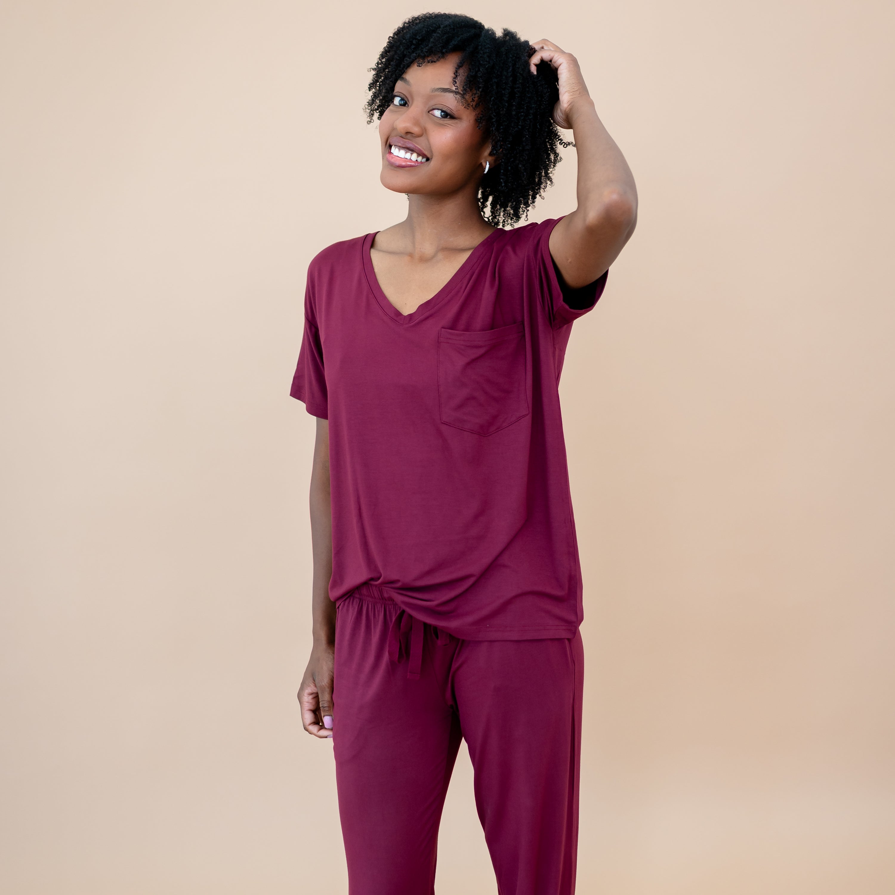 Female mode wearing the Women's Lounge Pants in Burgundy paired with a women's v-neck