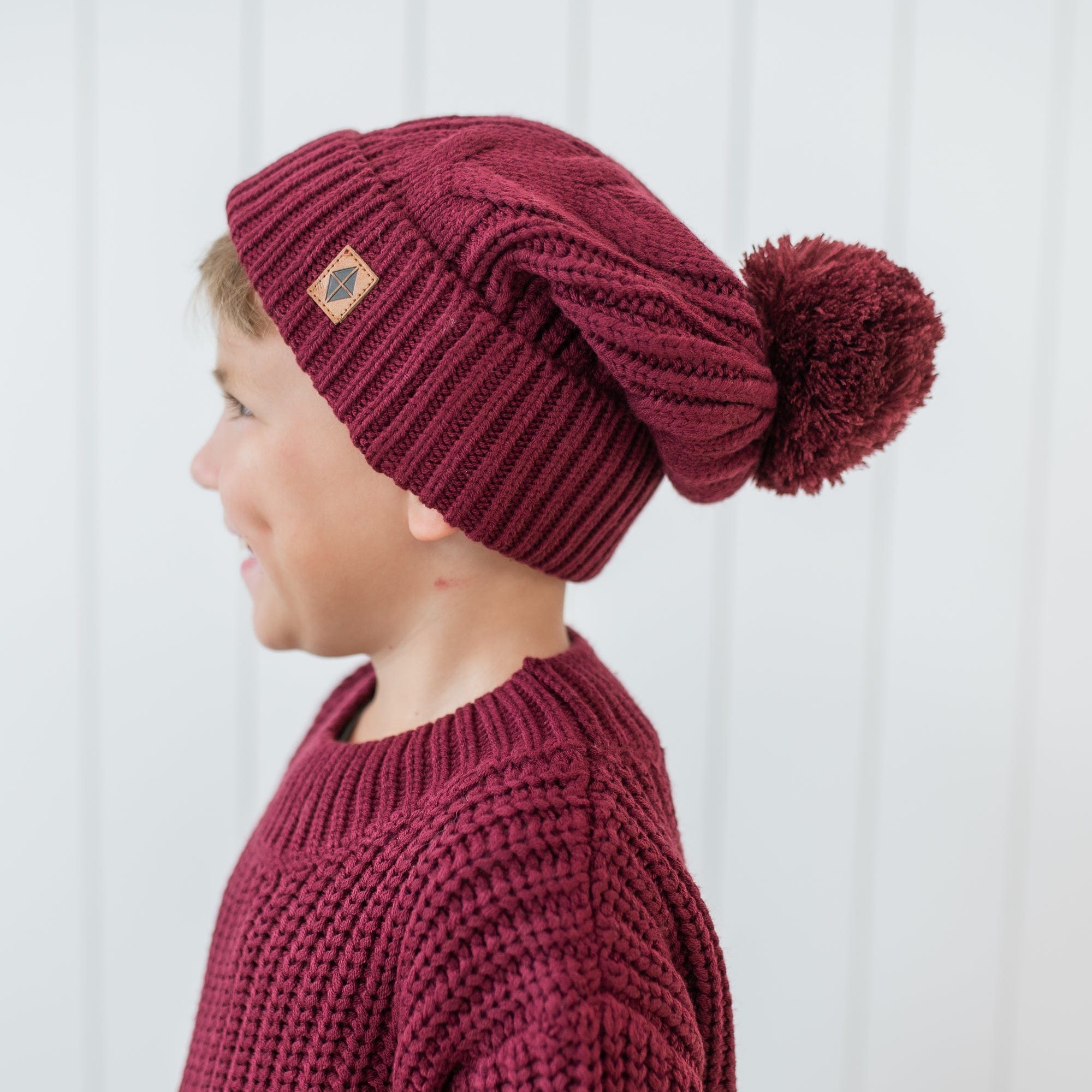 Chunky Cable Knit Beanie in Burgundy shown on a young boy