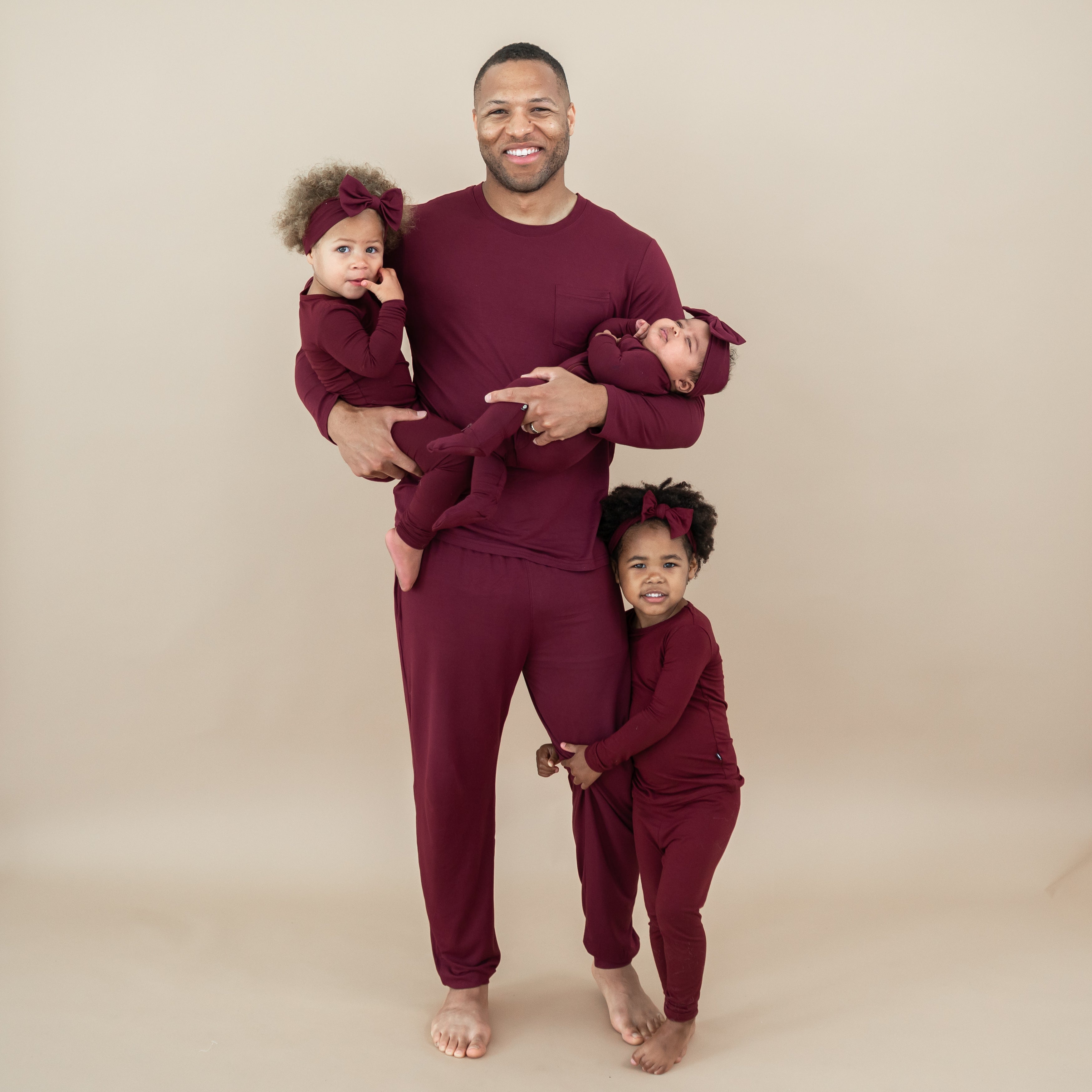 Family matching in Burgundy. Pictured are the Men's Jogger, toddler long sleeve pajama sets and zippered footie