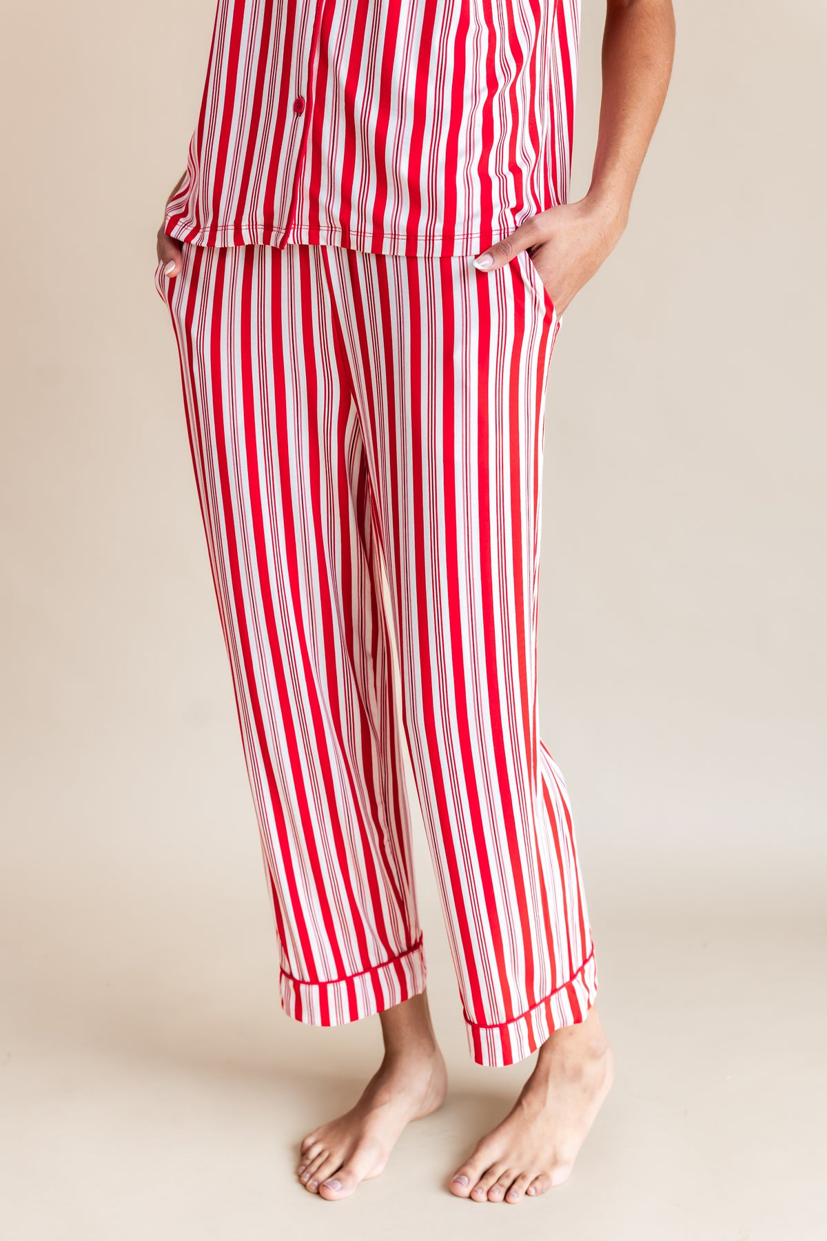 Modal showcasing the pajama's of Women's Short Sleeve Cropped Pajama Set with pockets in red and white Peppermint Stripes print on a beige background