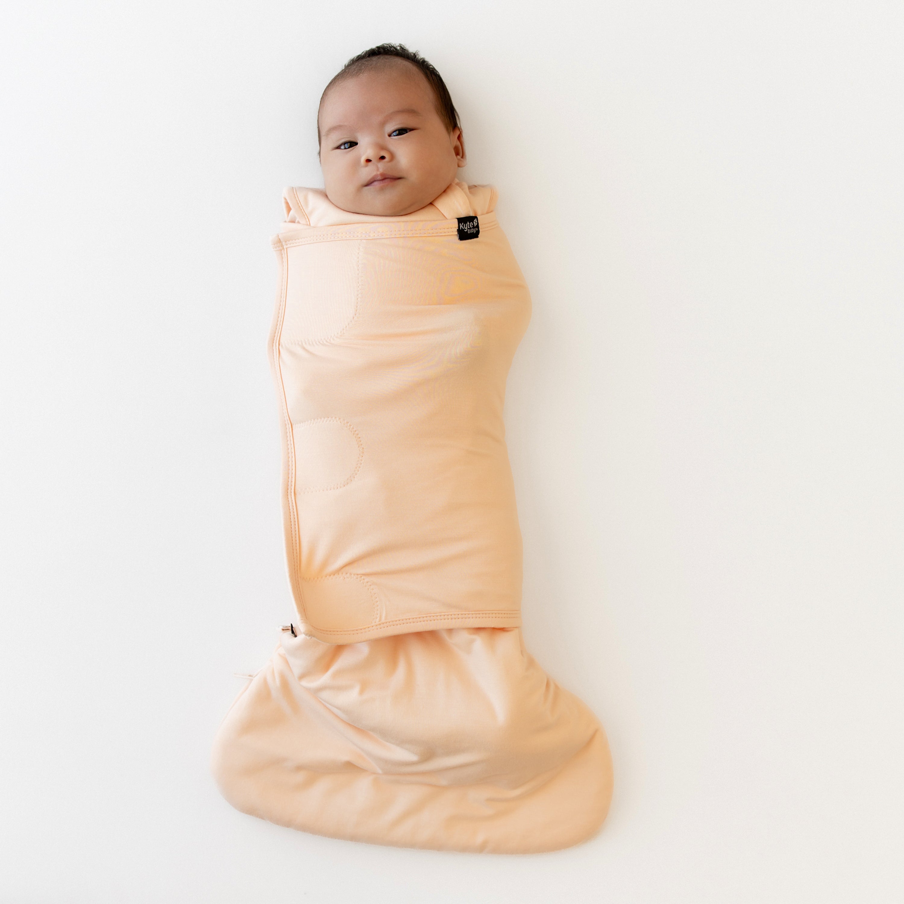 Infant laying down swaddled in Sleep Bag Swaddler in Canyon 1.0