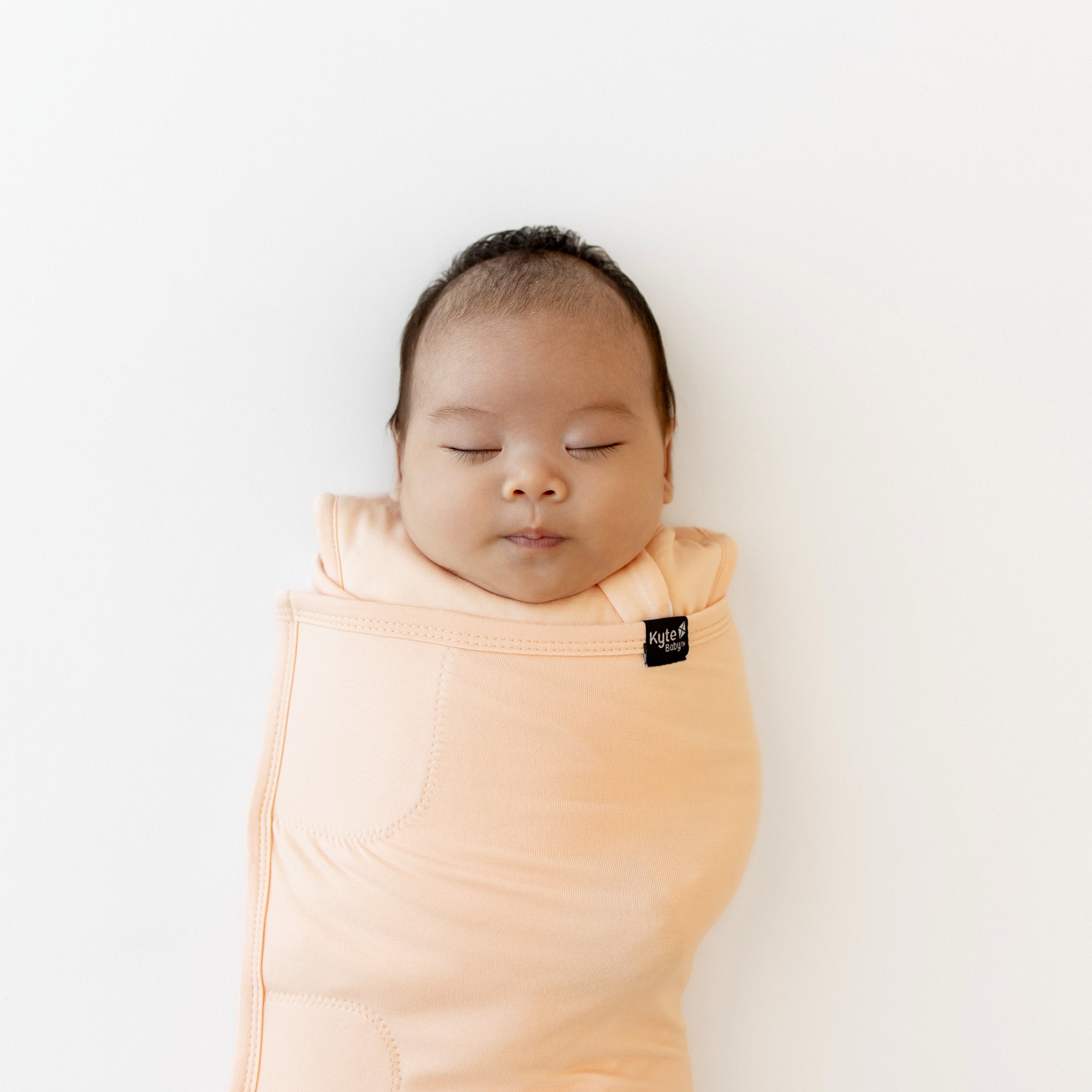 Close up of sleeping baby swaddled in the Sleep Bag Swaddler in Canyon 1.0