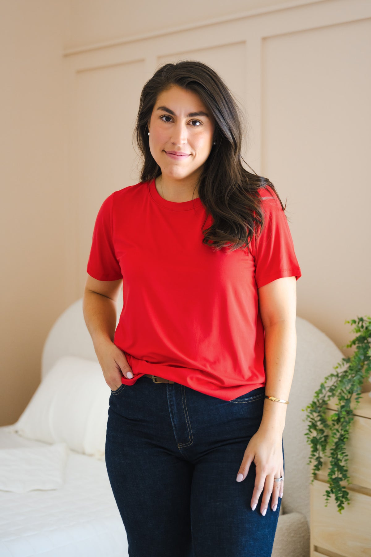 Model wearing Women's Crew Neck Tee in Cardinal over navy denim