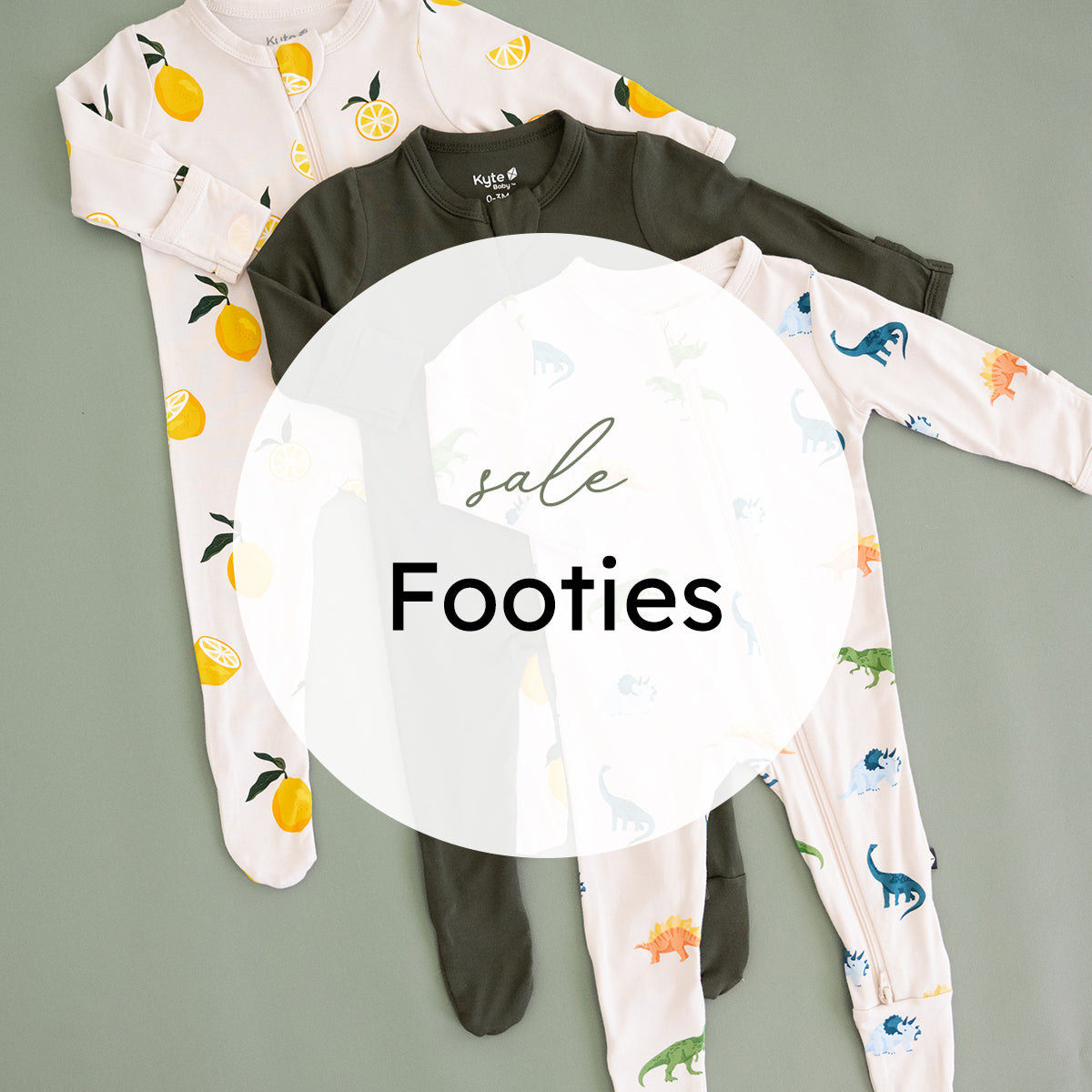 Three baby footed long-sleeve pajamas laid flat on a muted green background, with a large white circular sale overlay covering the center. The pajamas include a white set with yellow lemon prints, a dark olive green set, and a pale set with small dinosaur.