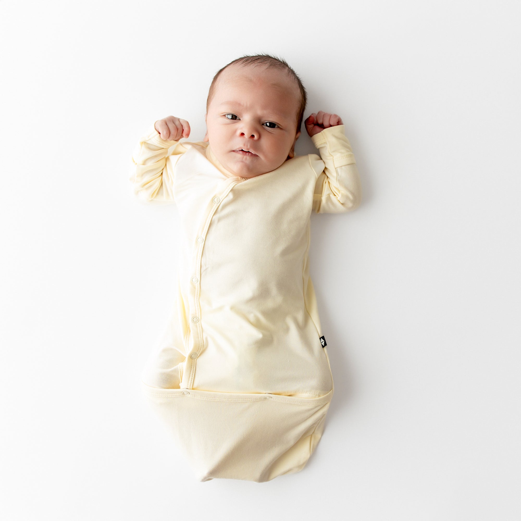 Newborn wearing Bundler in a pale yellow color