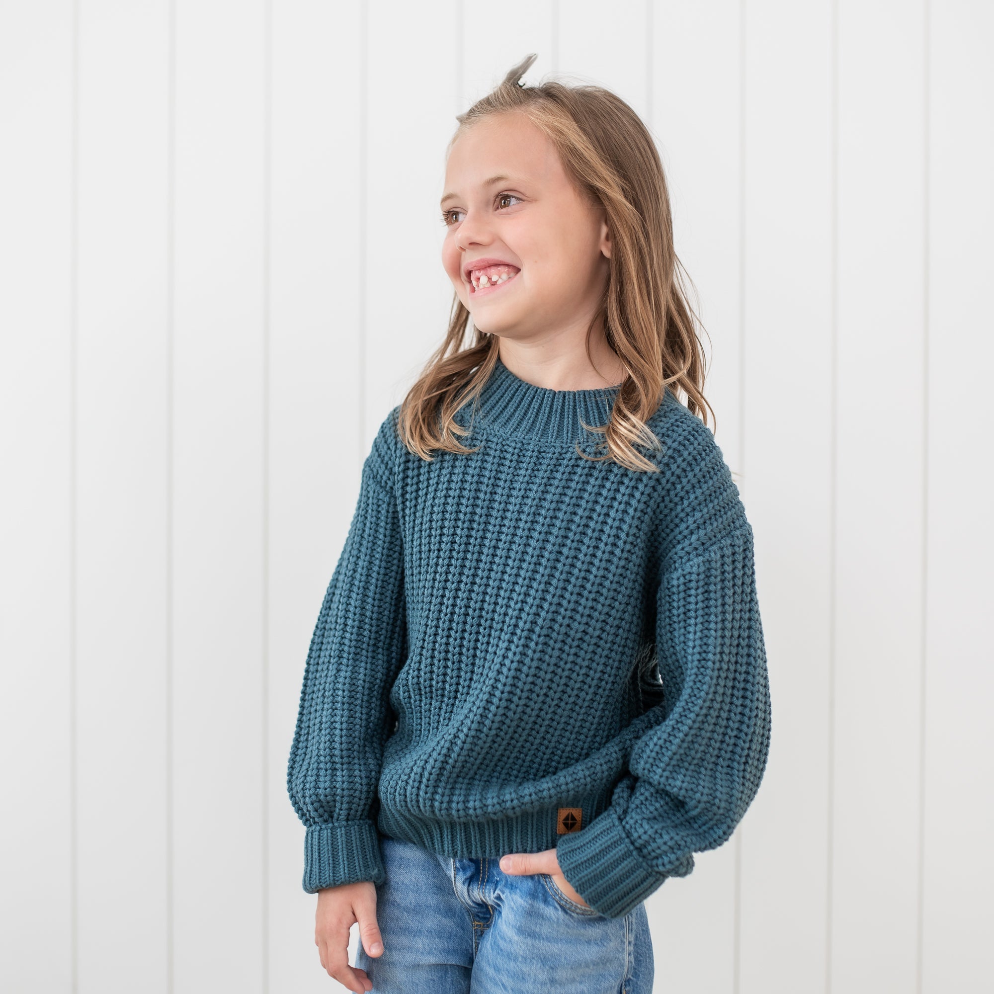 Smiling girl wearing the Chunky Knit Sweater in Atlantic with one hand in her jean pocket