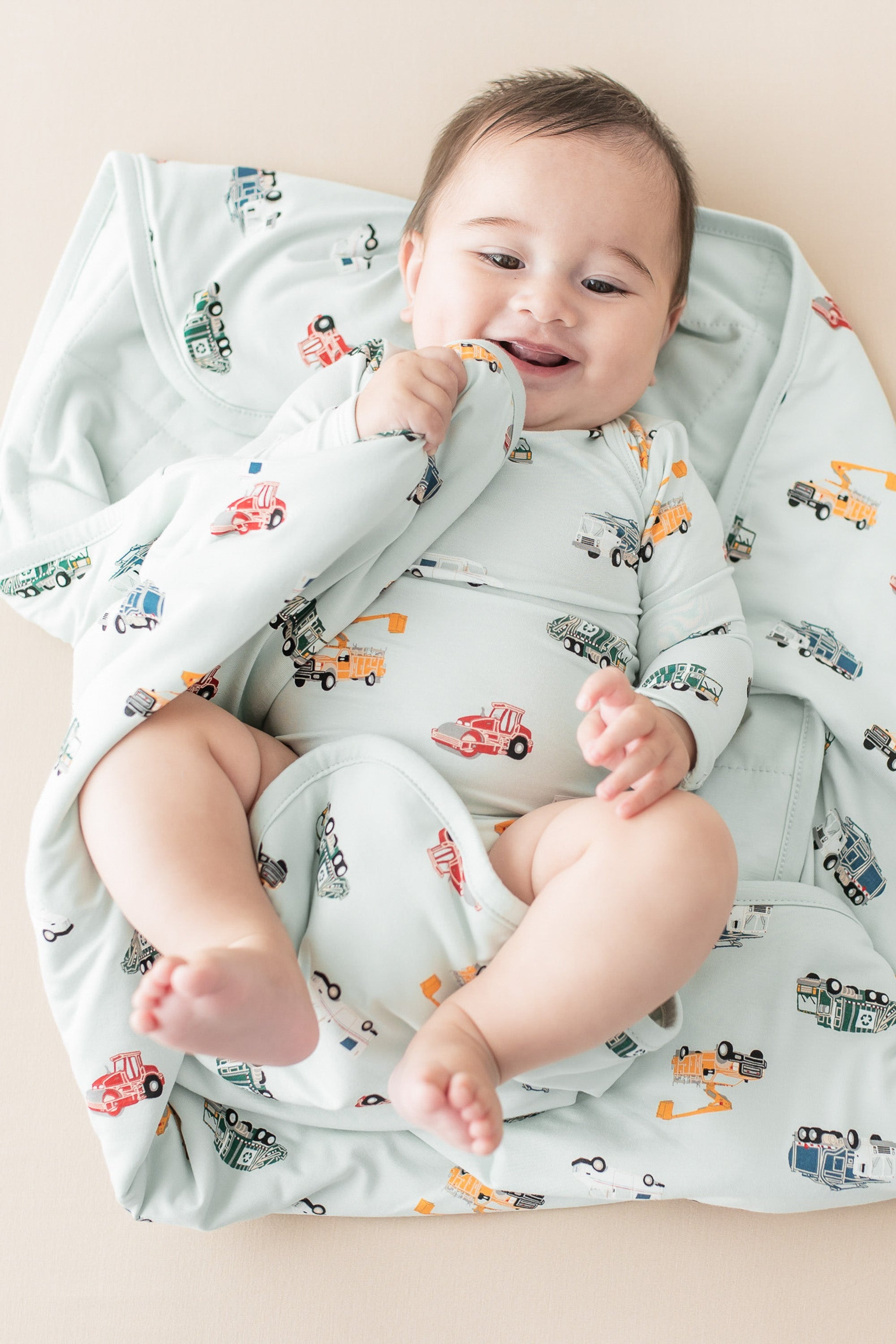 Infant laying on a Baby Blanket in City Vehicles 1.0 wearing a matching long sleeve bodysuit