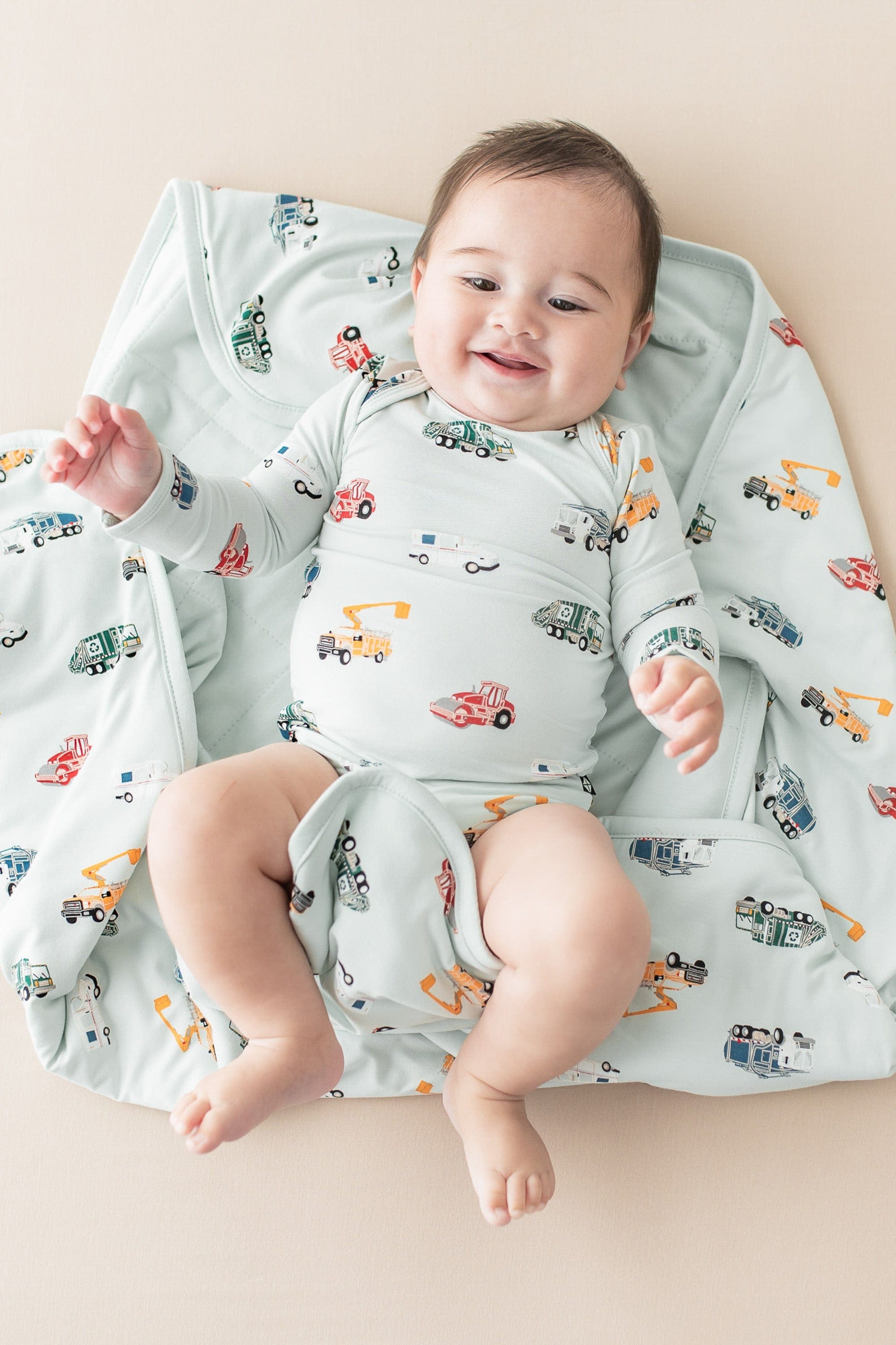 Infant laying on a Baby Blanket in City Vehicles 1.0 wearing a matching long sleeve bodysuit