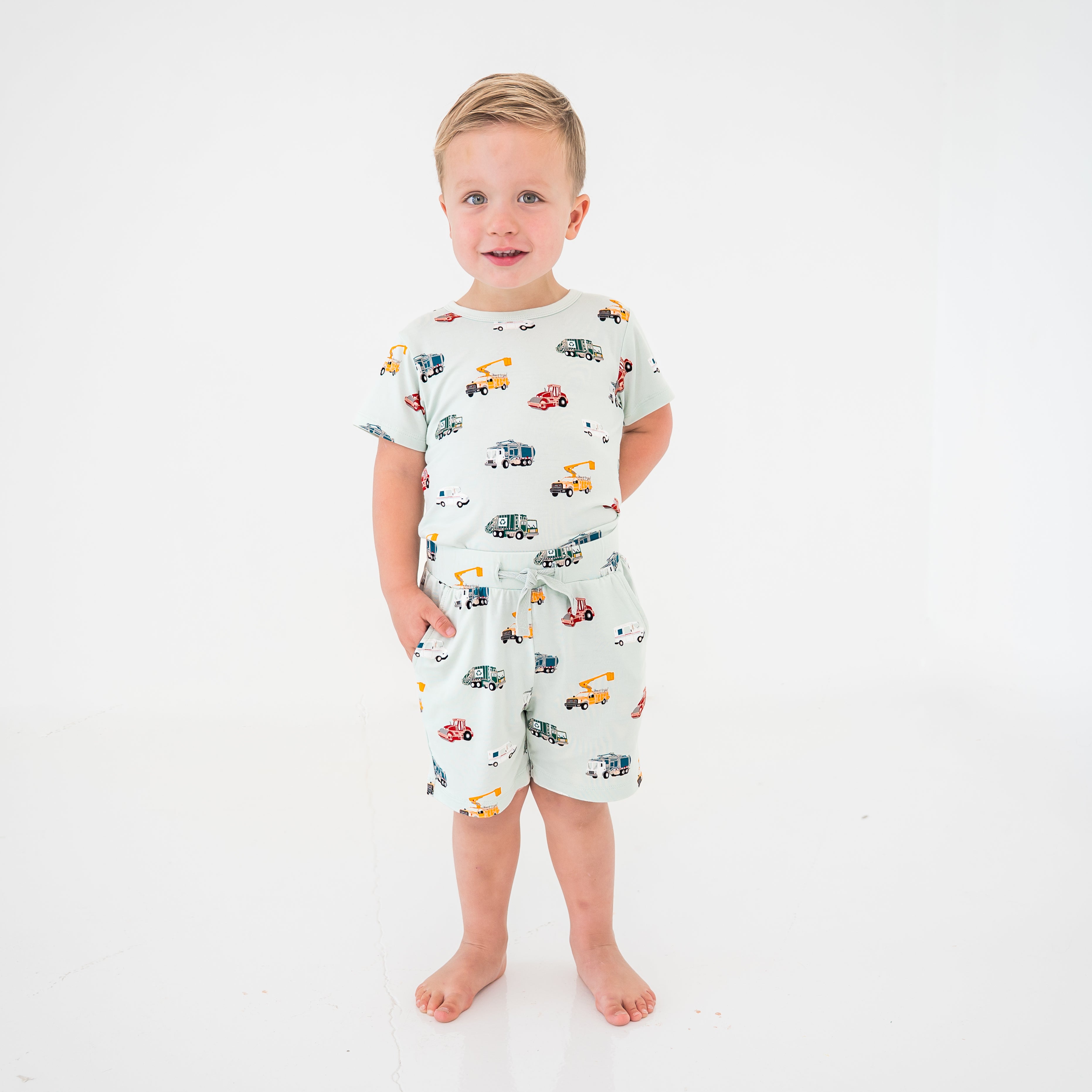 Young boy modeling the Drawstring Short in City Vehicles paired with a matching basic tee shirt