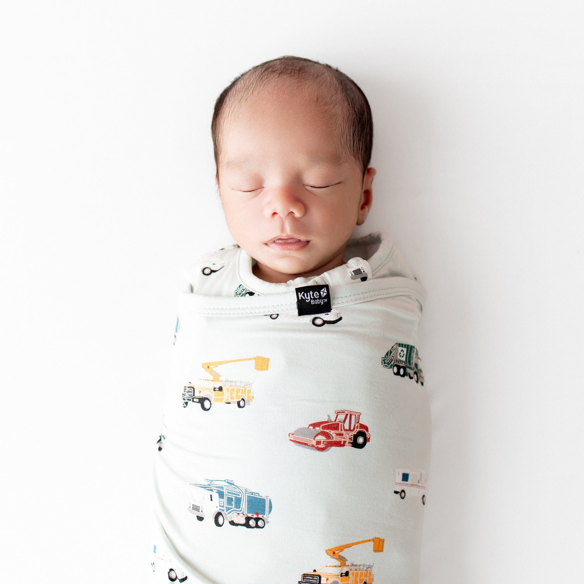 Close up of sleeping newborn wearing the Sleep Bag Swaddler in City Vehicles 1.0