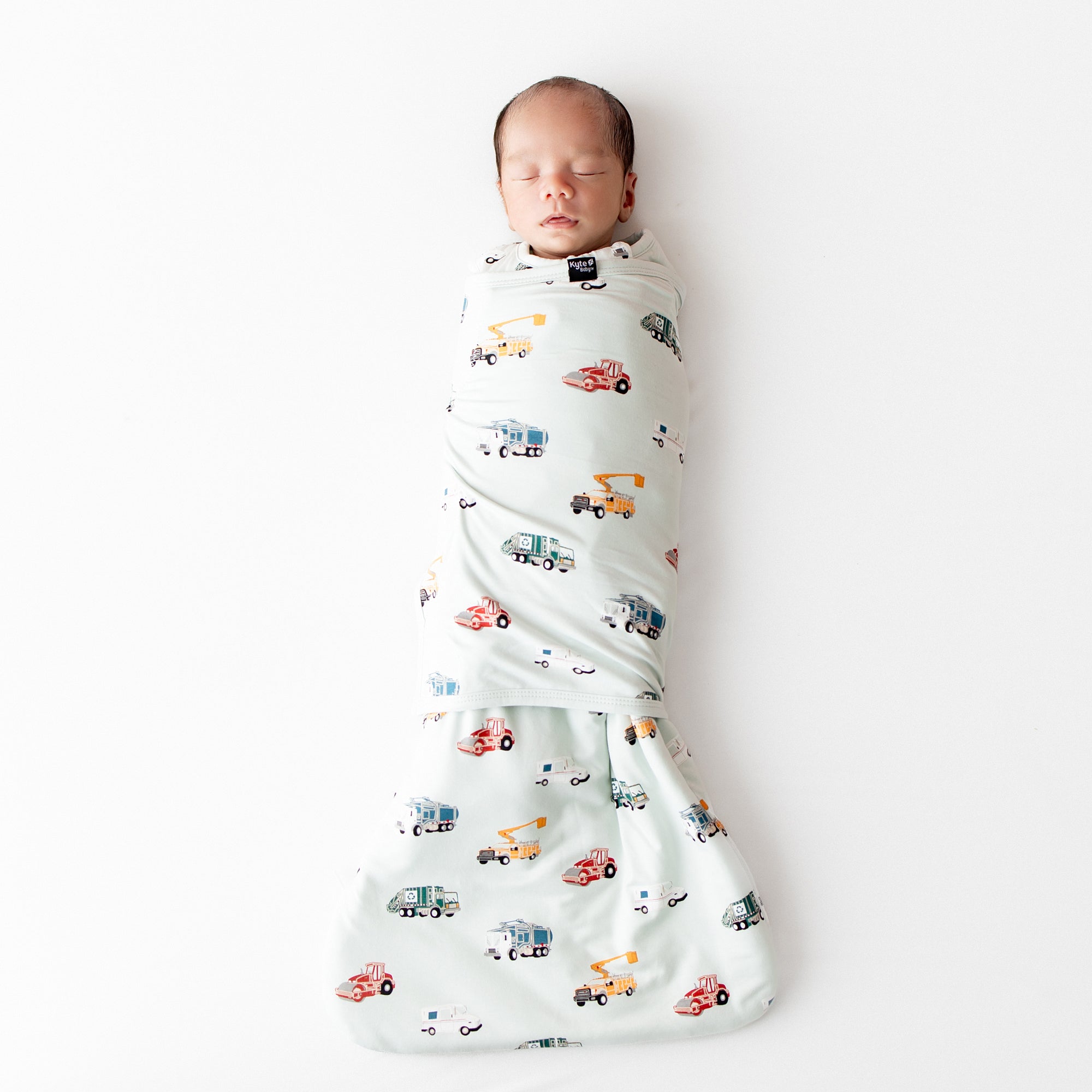 Sleeping newborn wearing the soft and breathable Sleep Bag Swaddler in City Vehicles 1.0