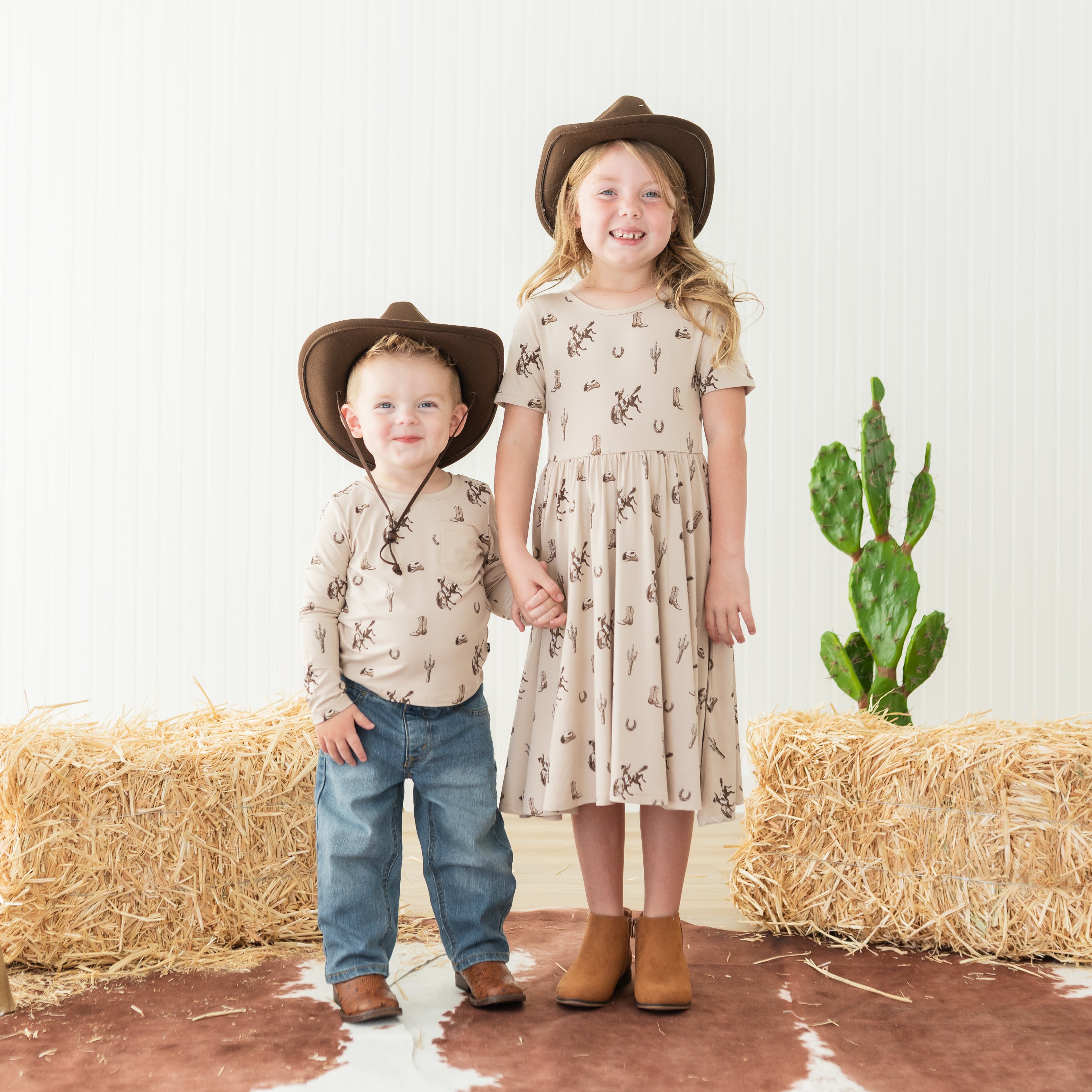 Brother and sister holding hands matching in the Classic Cowboy print