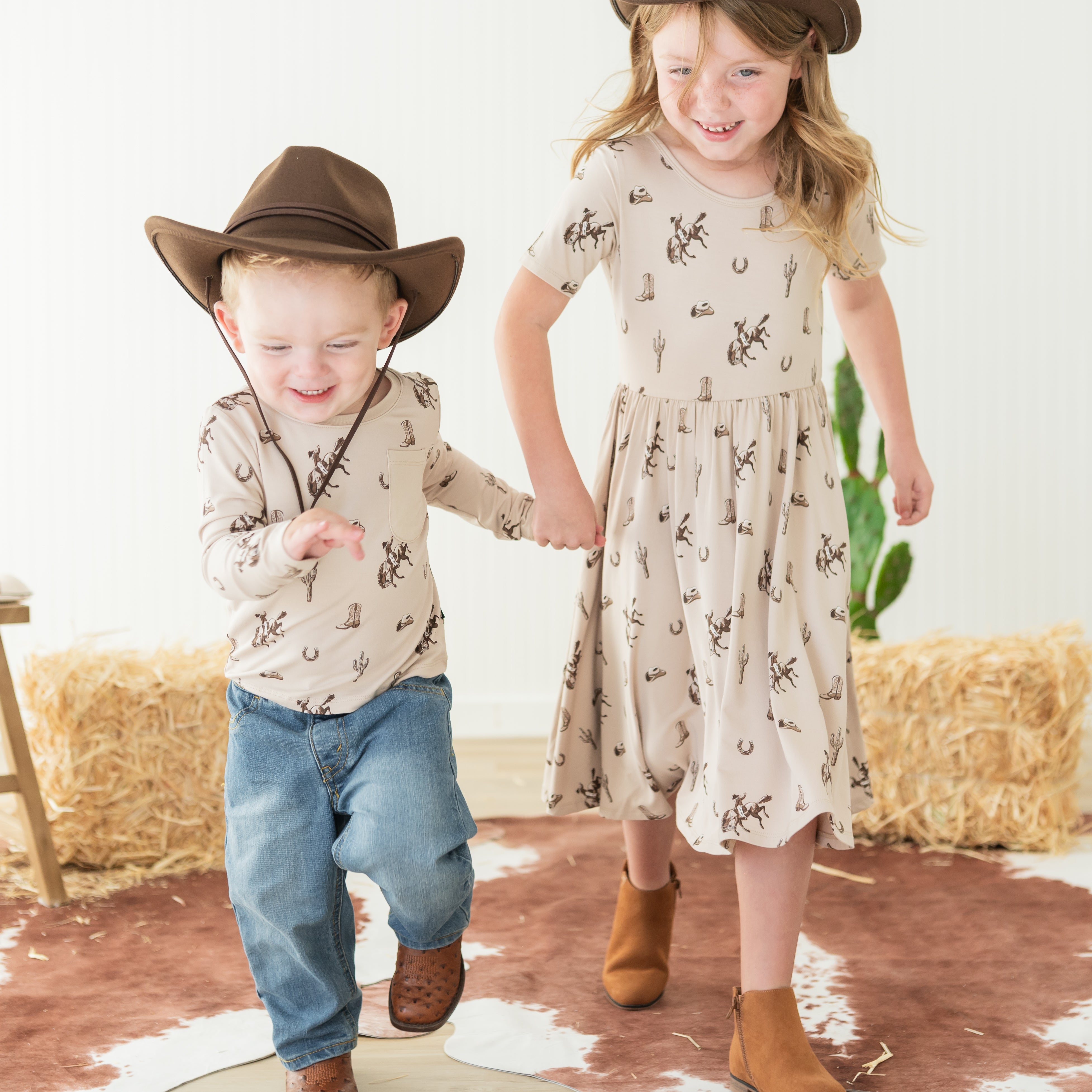 Brother and sister walking holding hands matching in the Classic cowboy print