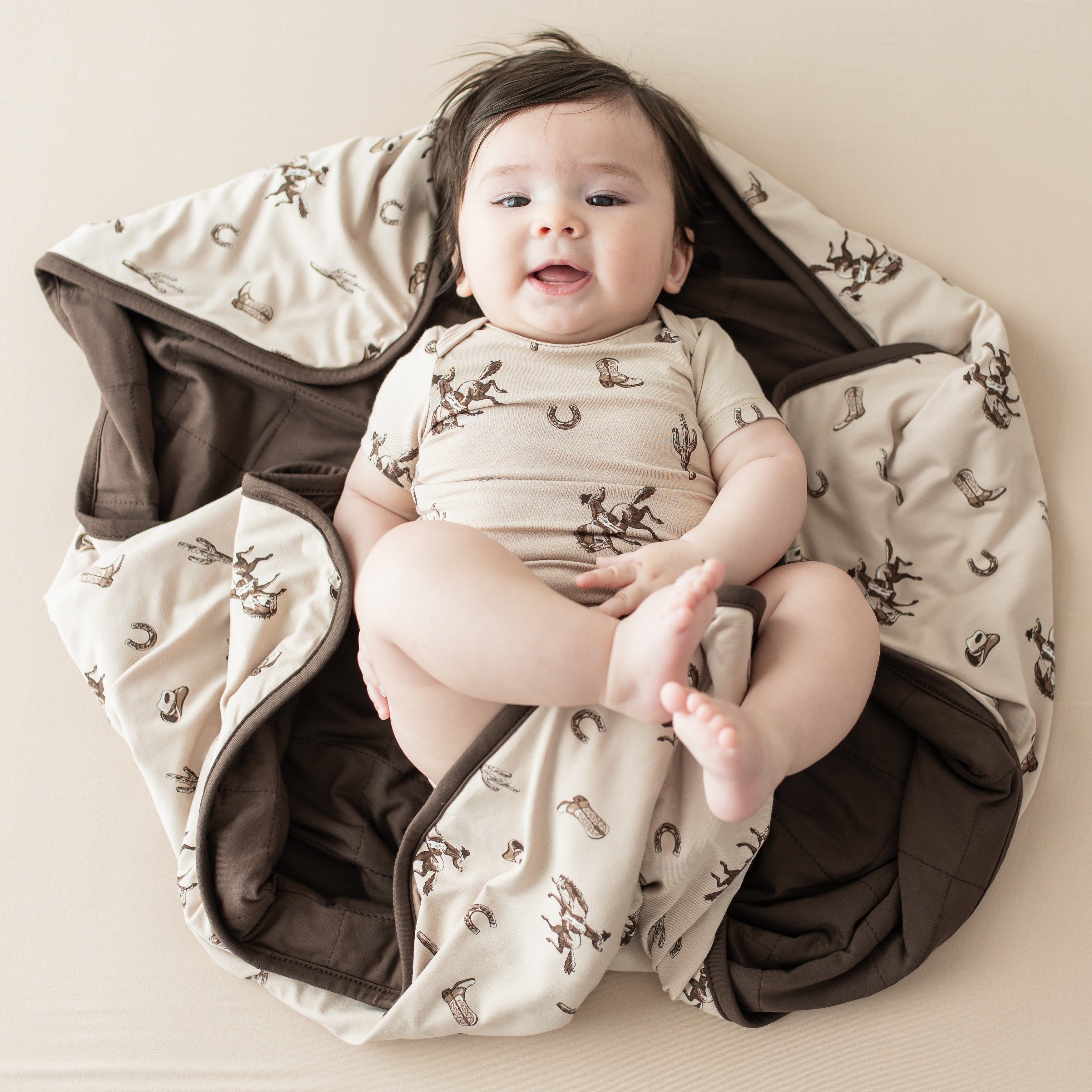 Infant laying on a Baby Blanket in Classic Cowboy wearing a matching short sleeve bodysuit