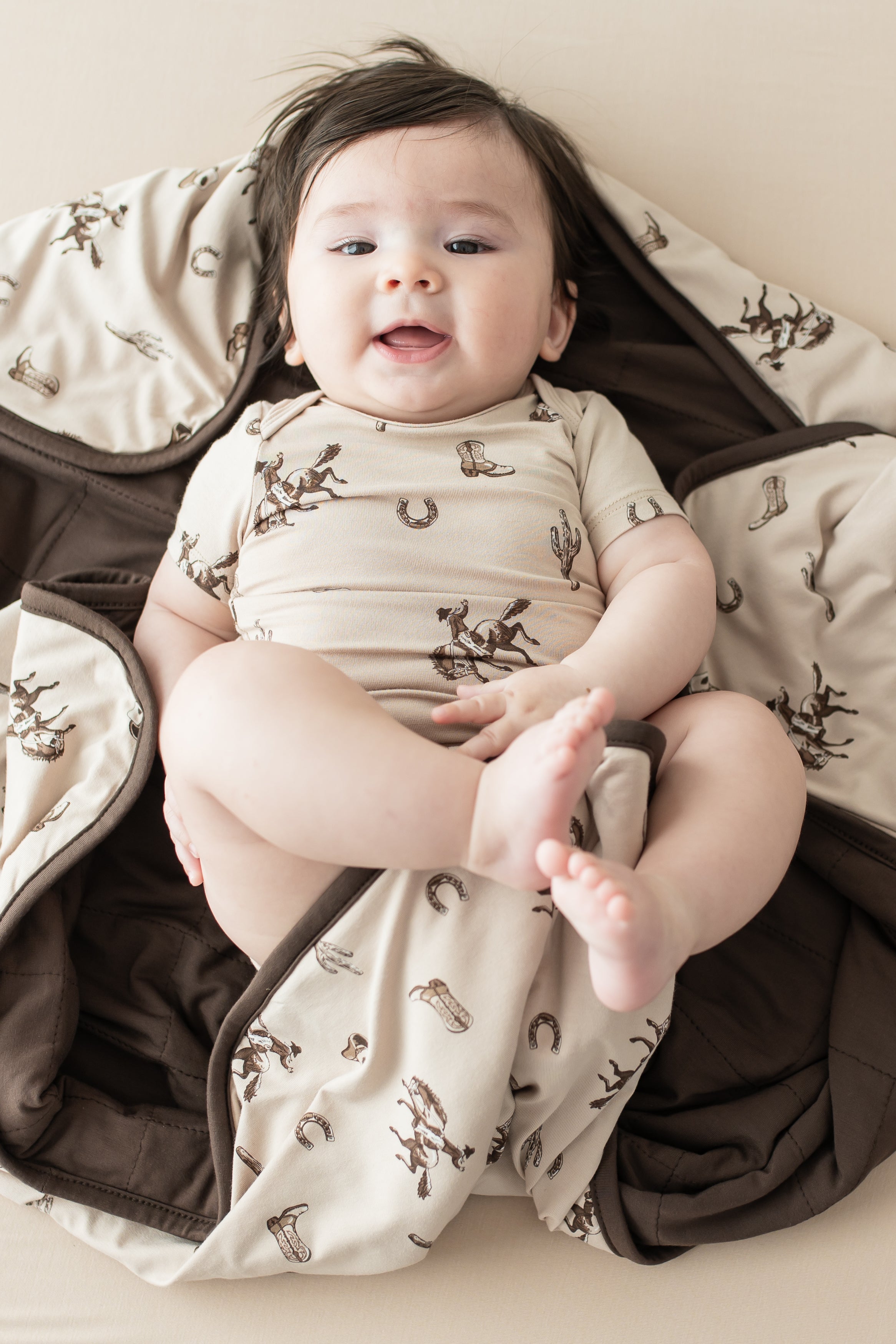 Infant laying on a Baby Blanket in Classic Cowboy wearing a matching short sleeve bodysuit