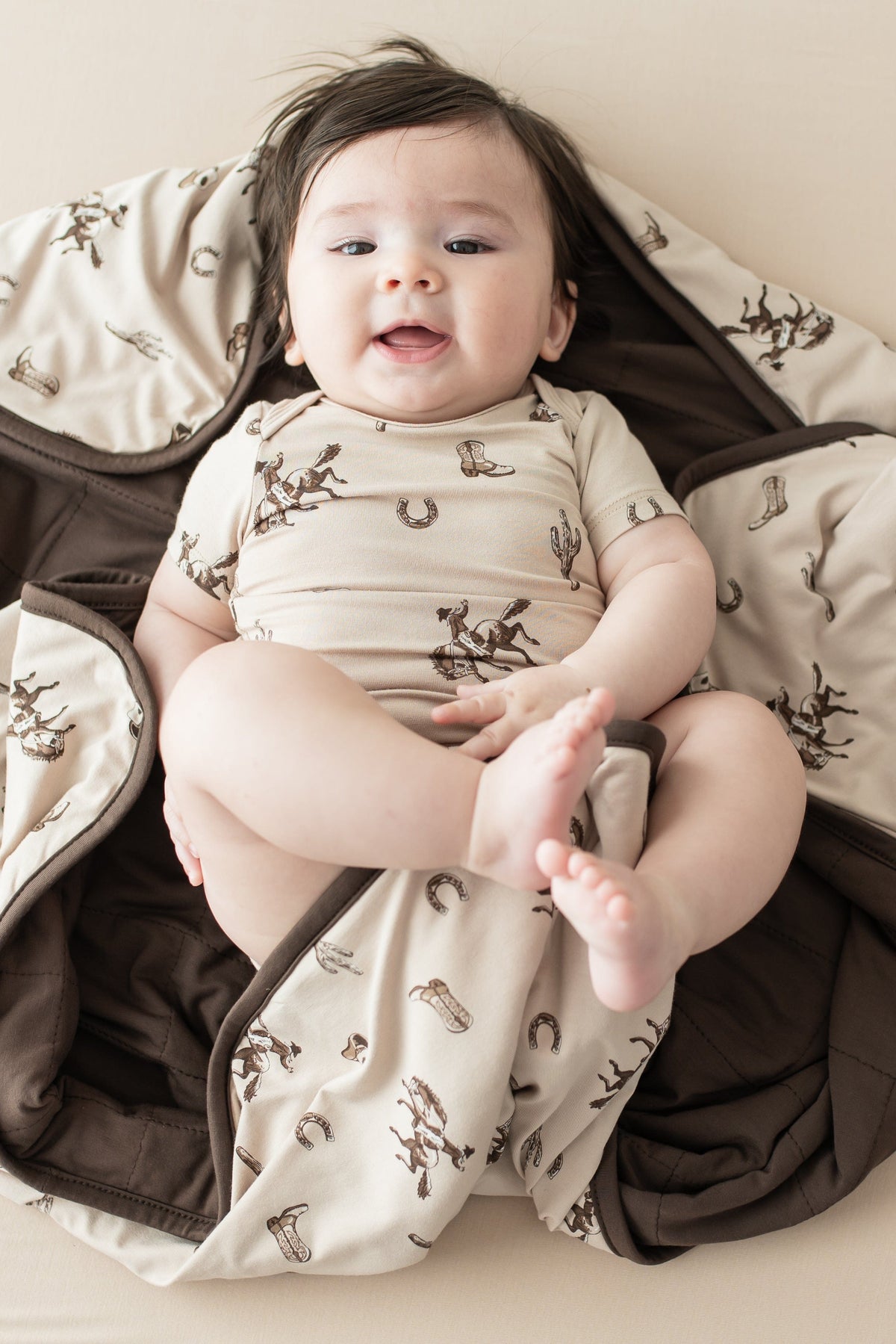 Infant laying on a Baby Blanket in Classic Cowboy wearing a matching short sleeve bodysuit