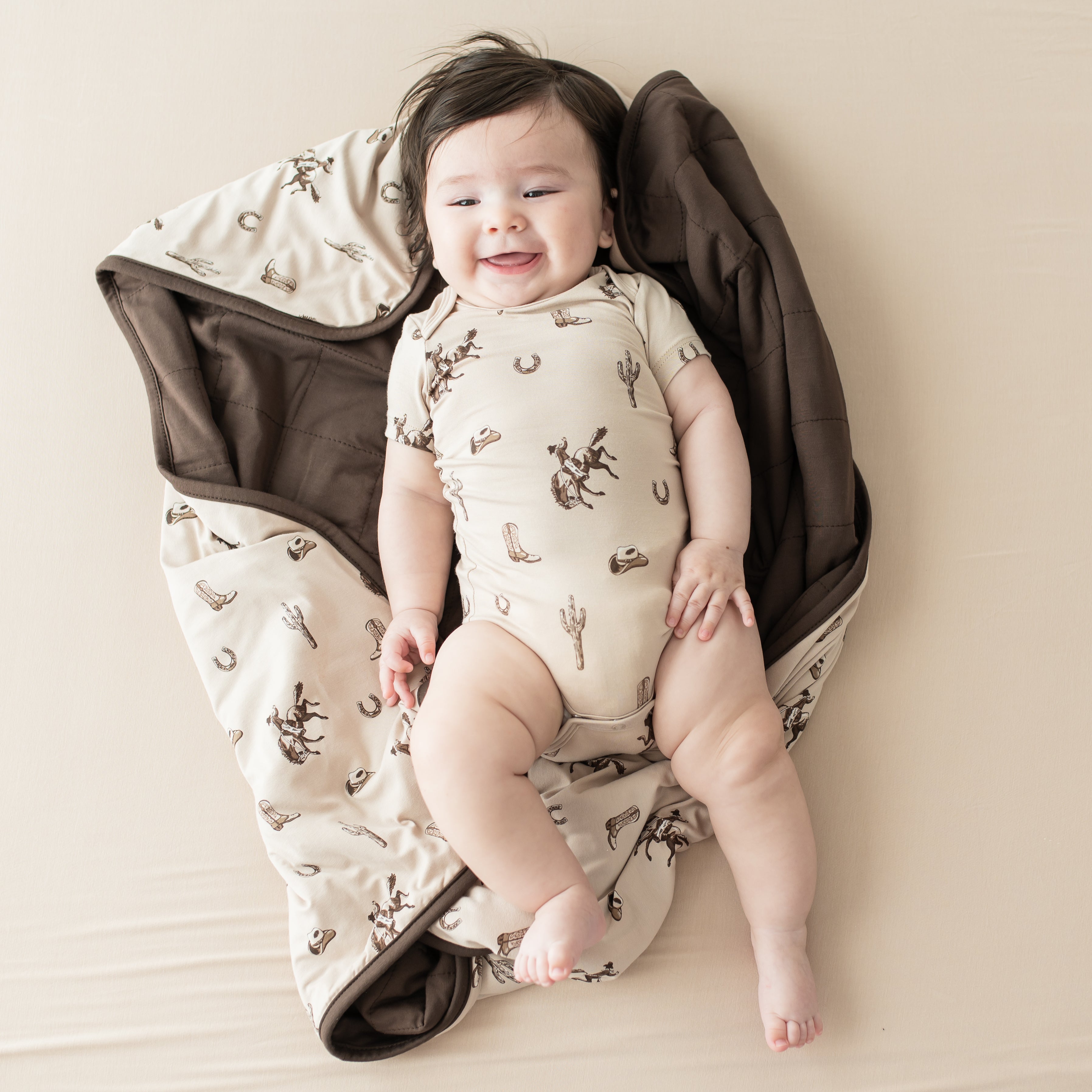 Infant laying on a Baby Blanket in Classic Cowboy wearing a matching short sleeve bodysuit