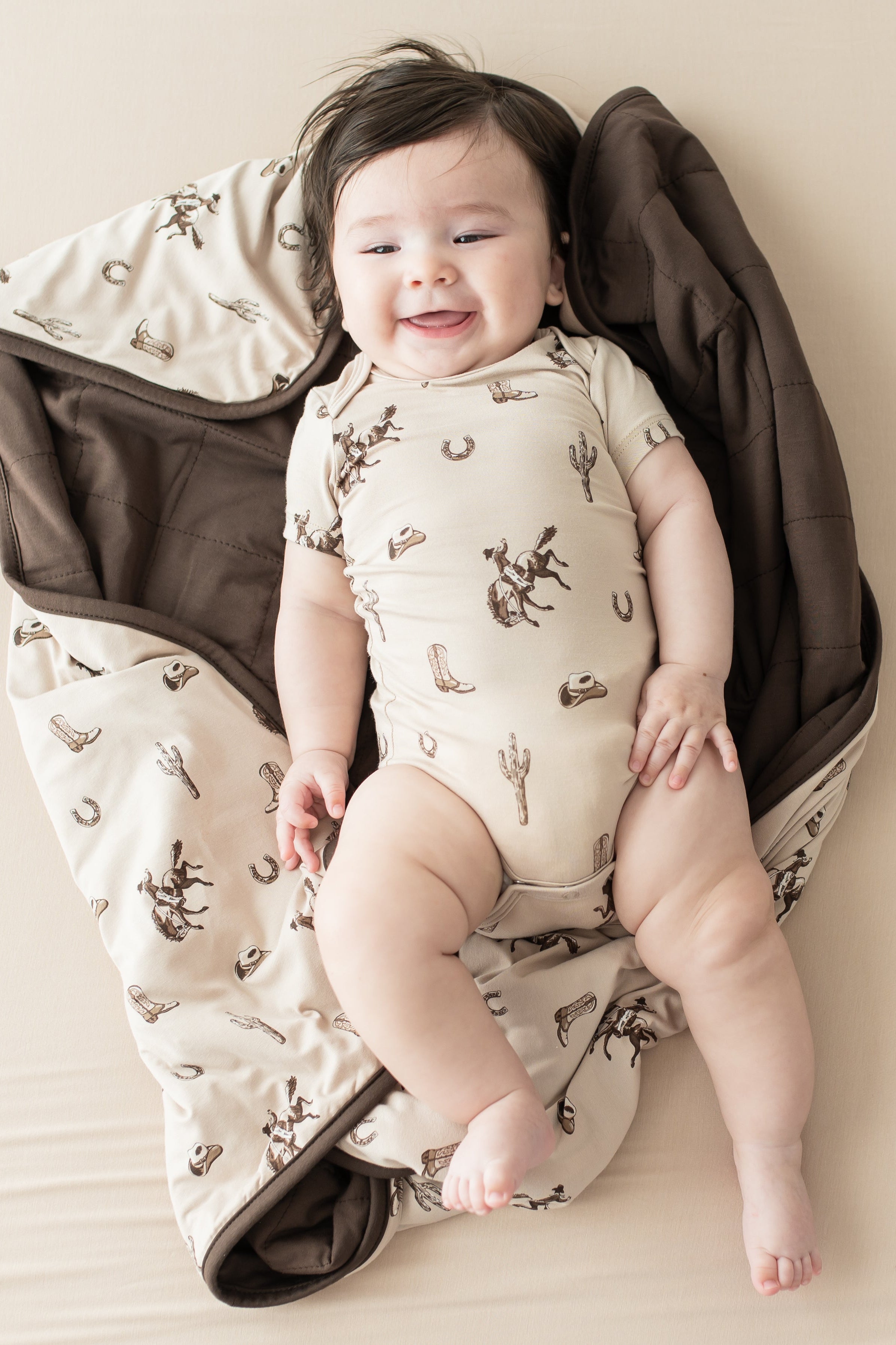Infant laying on a Baby Blanket in Classic Cowboy wearing a matching short sleeve bodysuit
