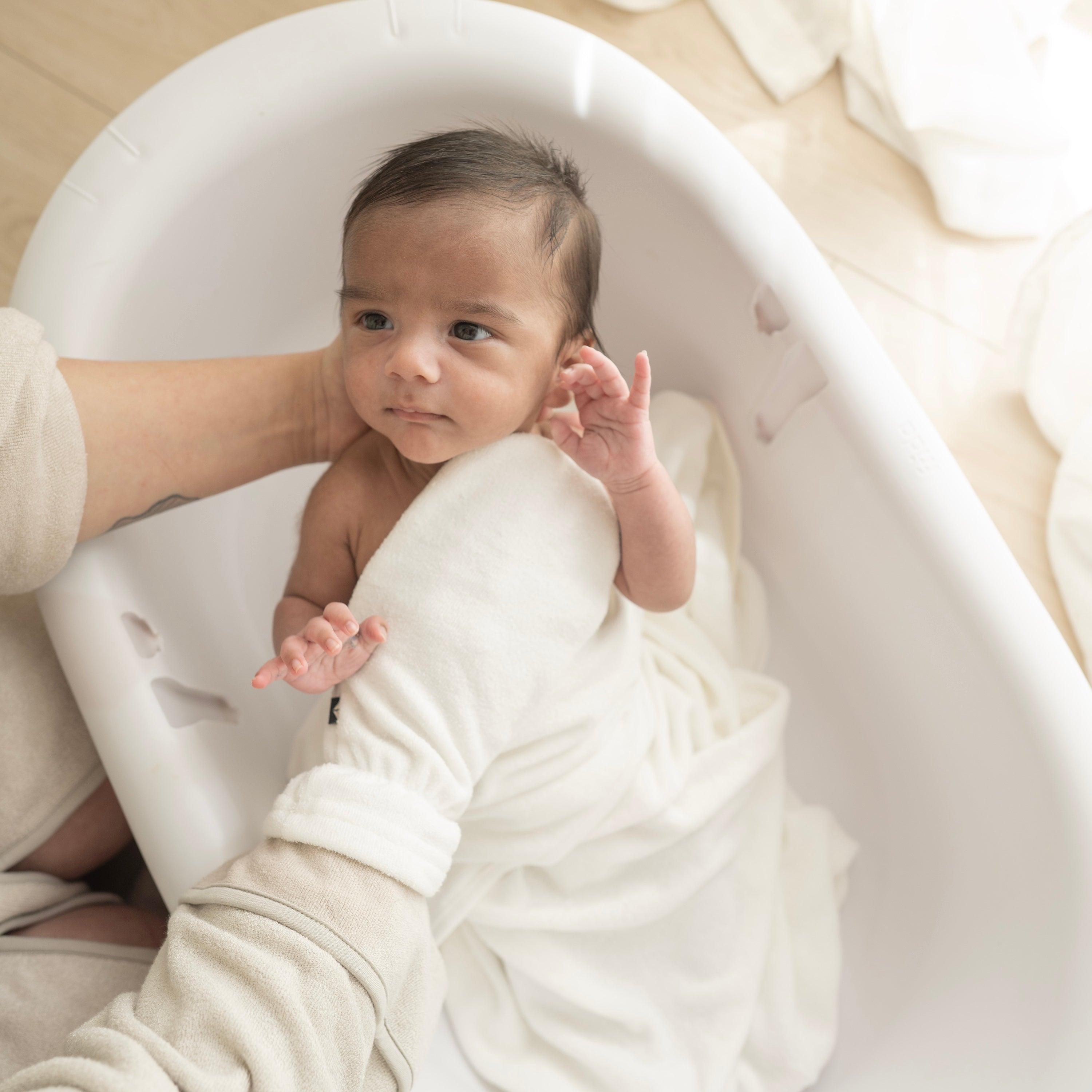 Parent using Terry Bath Mitt in Cloud White for newborn bath