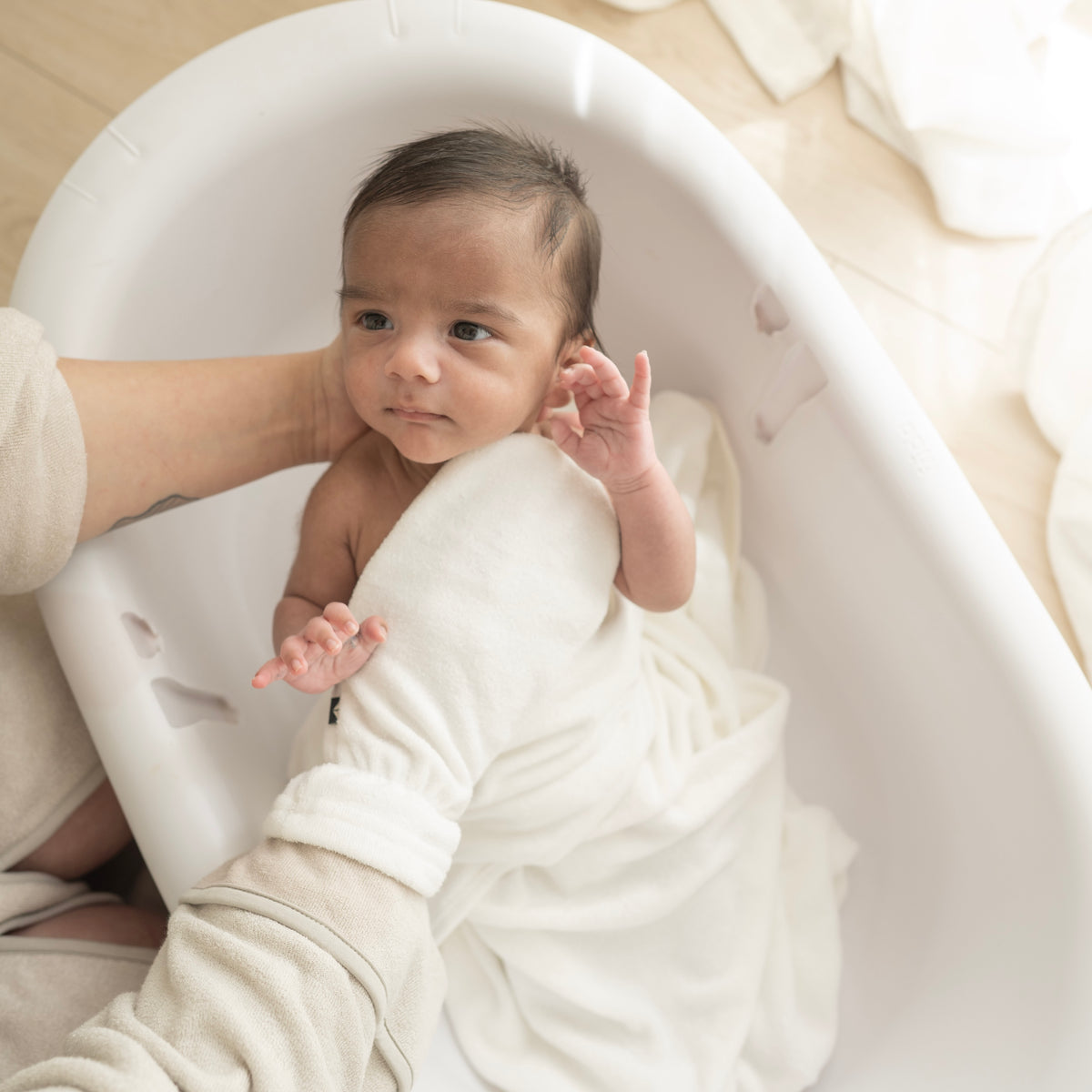 Parent using Terry Bath Mitt in Cloud White for newborn bath