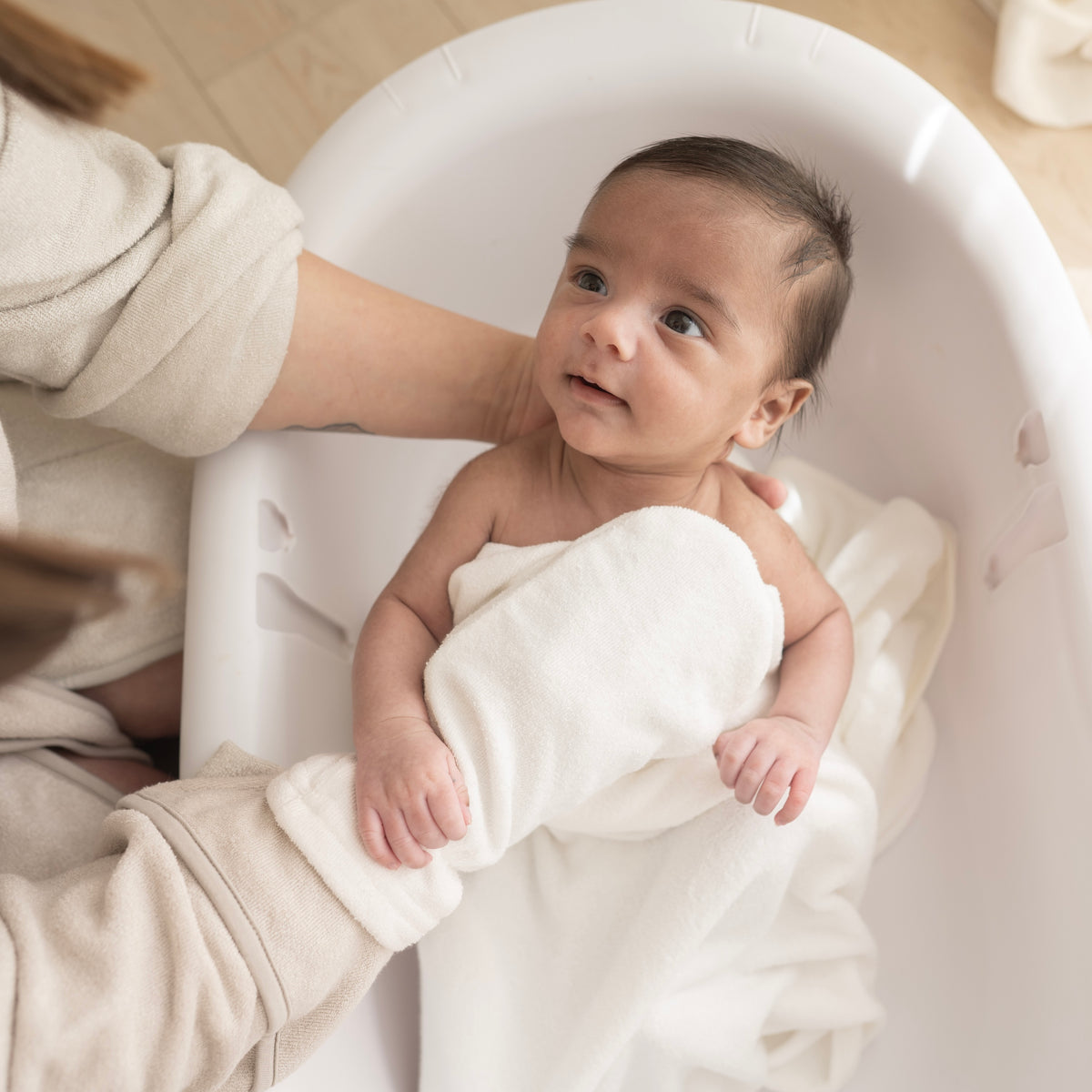 Parent using White Terry Bath Mitt for newborn bath