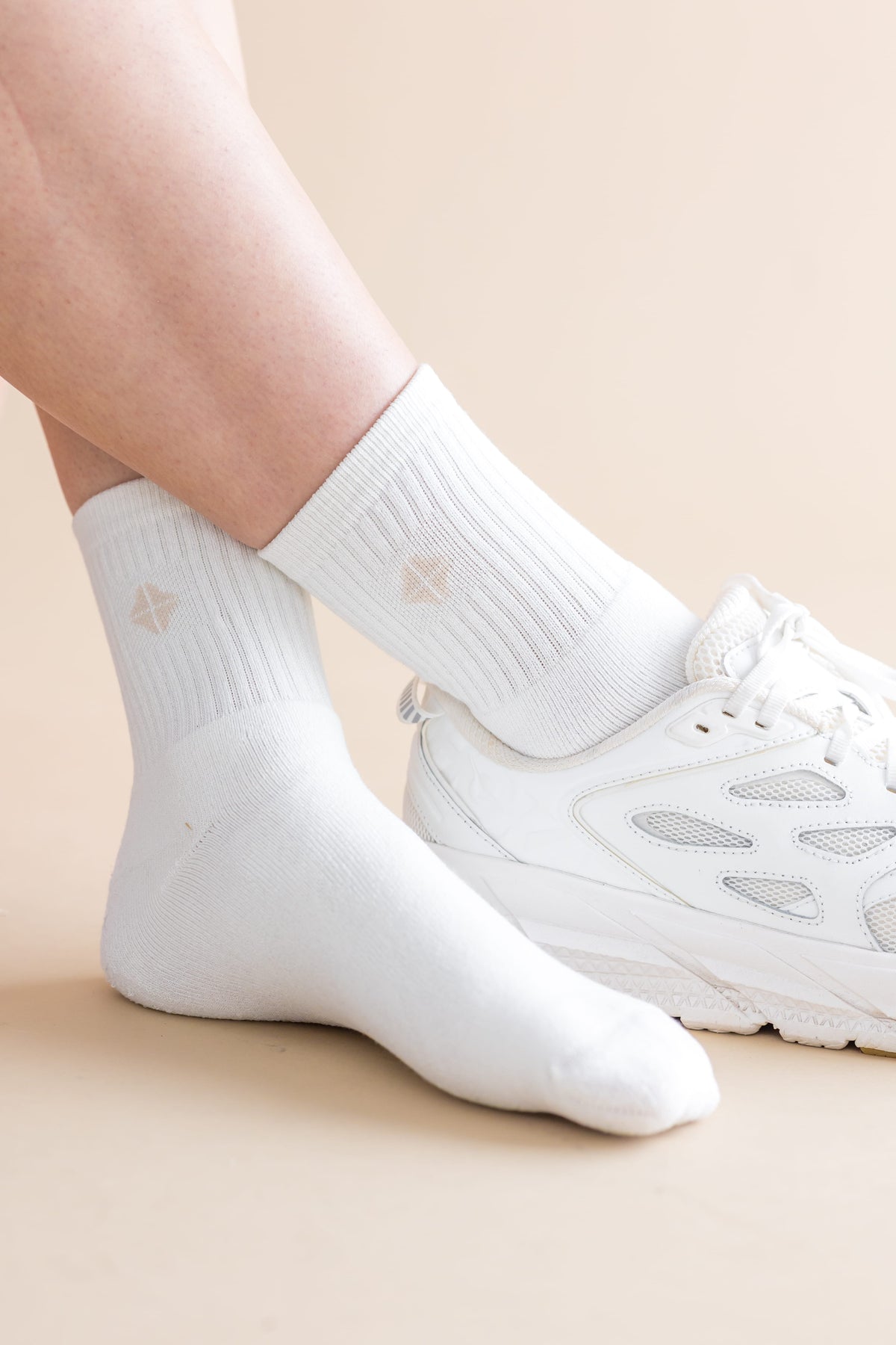 Adult Crew Socks in Cloud shown on a model with a white sneaker on one foot