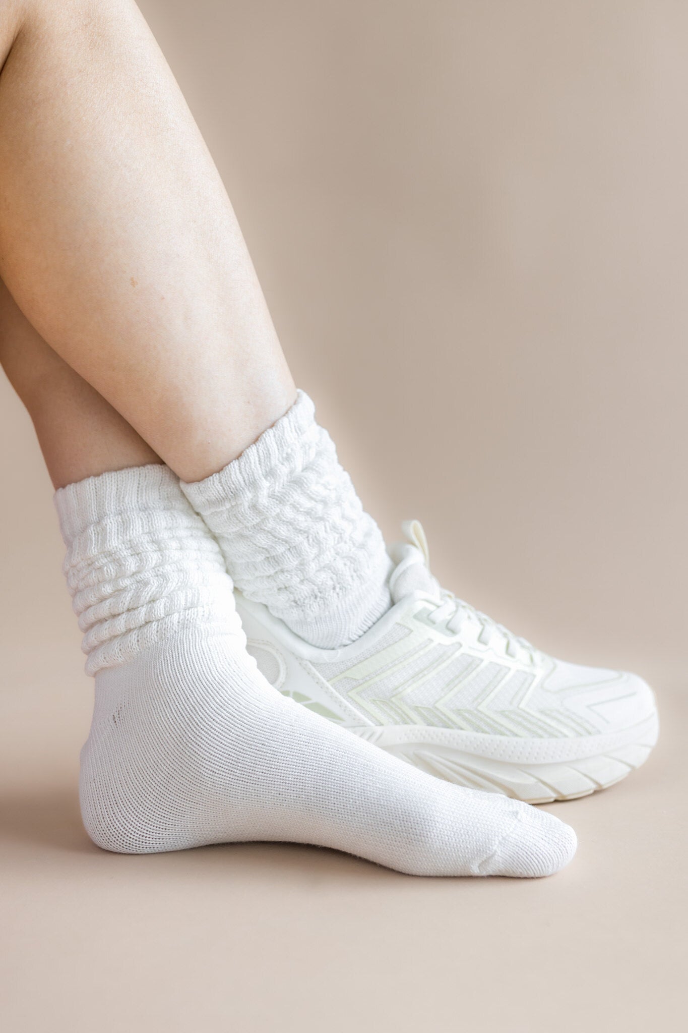 White socks worn with white shoes on a beige background