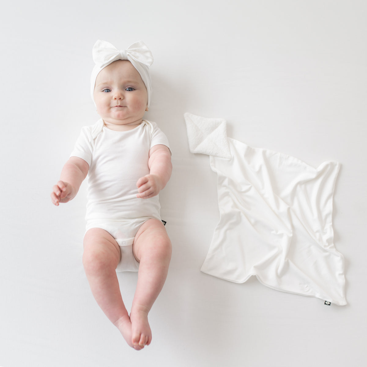 Baby wearing Bow Headband in Cloud next to Cloud Kite Lovey
