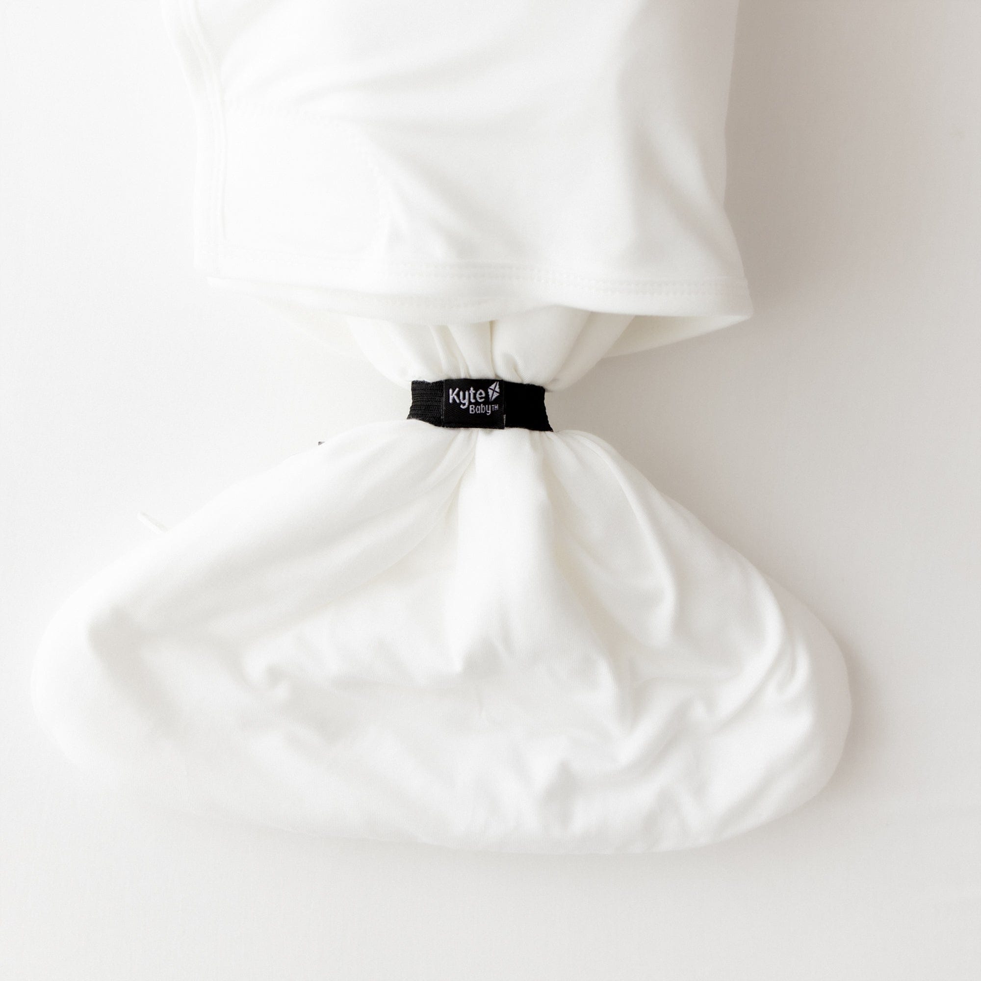 White bamboo sleep bag swaddler with a black elastic on a white background