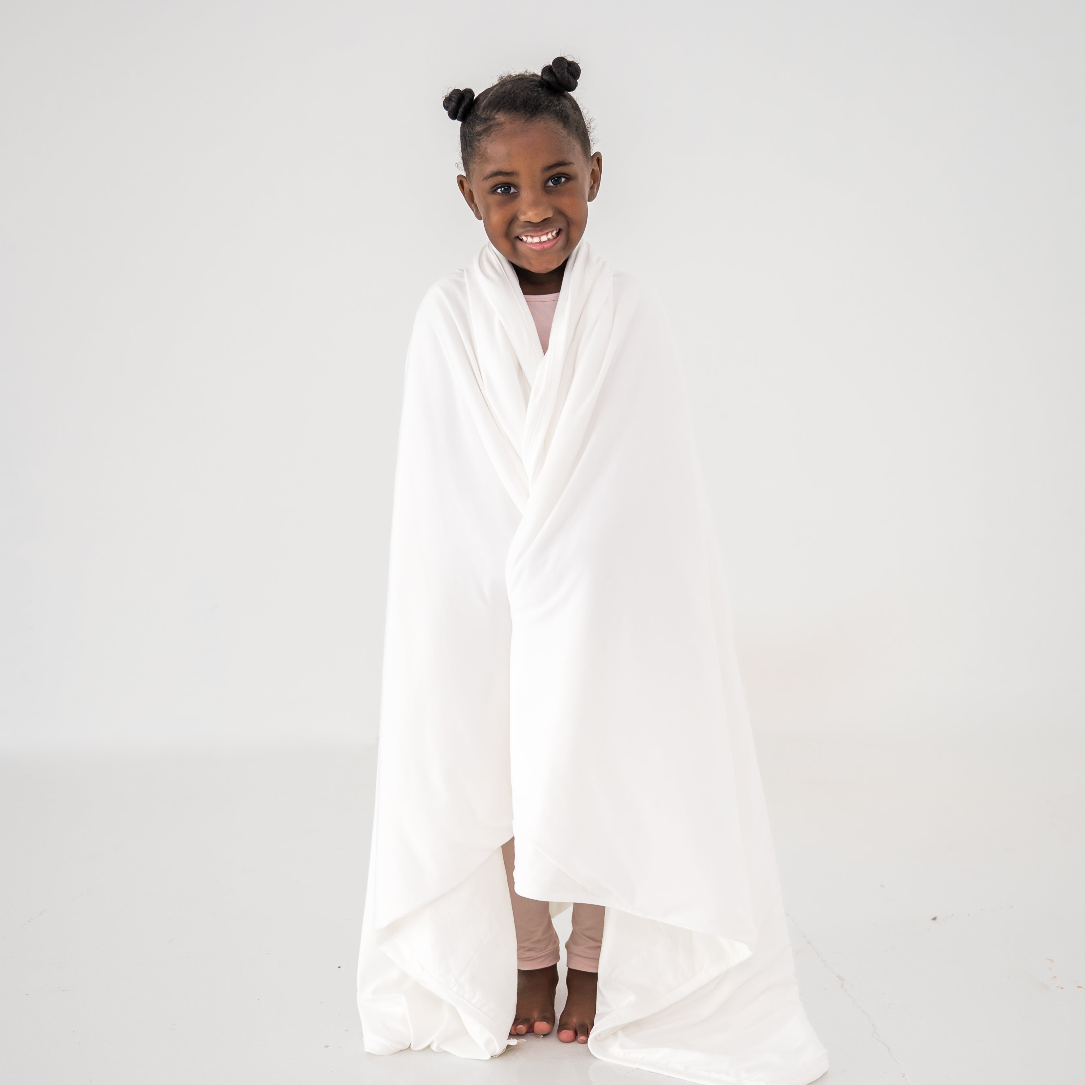 Child wrapped in a buttery soft bamboo white blanket
