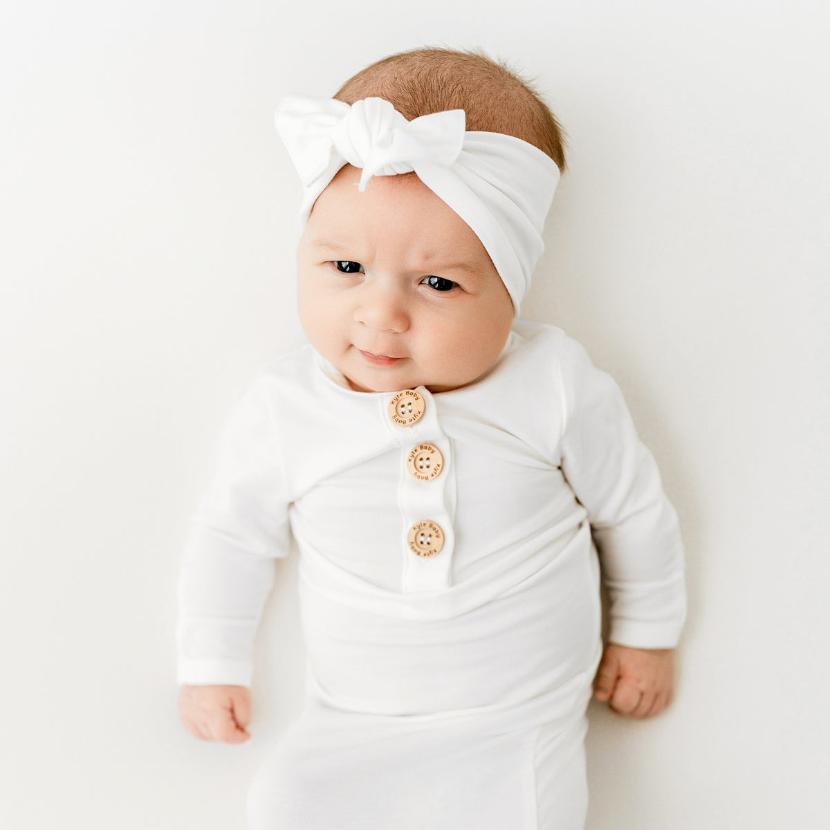 Baby wearing Knotted Gown with Bow Headband in Cloud white