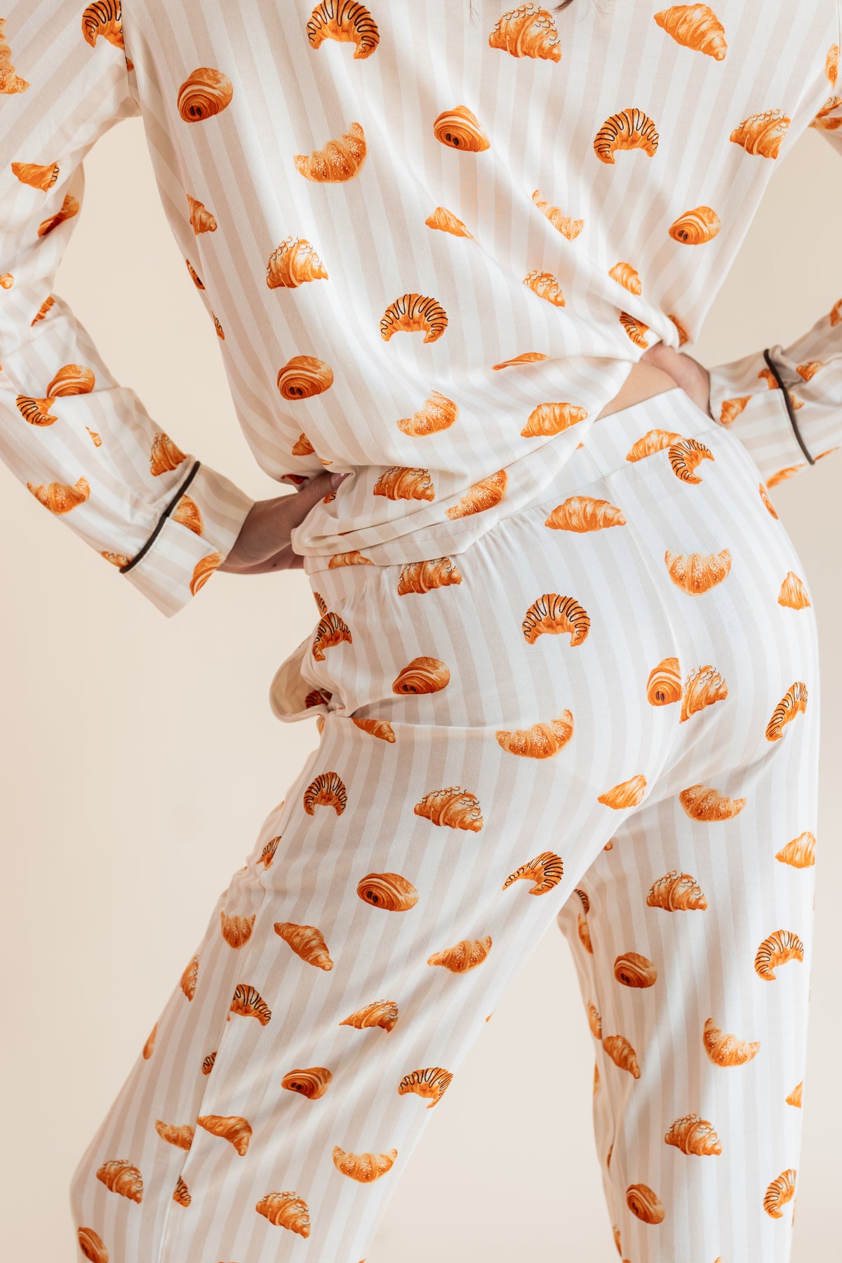 Back side of model wearing Long-Sleeved Women's Pajama Set in Croissant print on a beige background