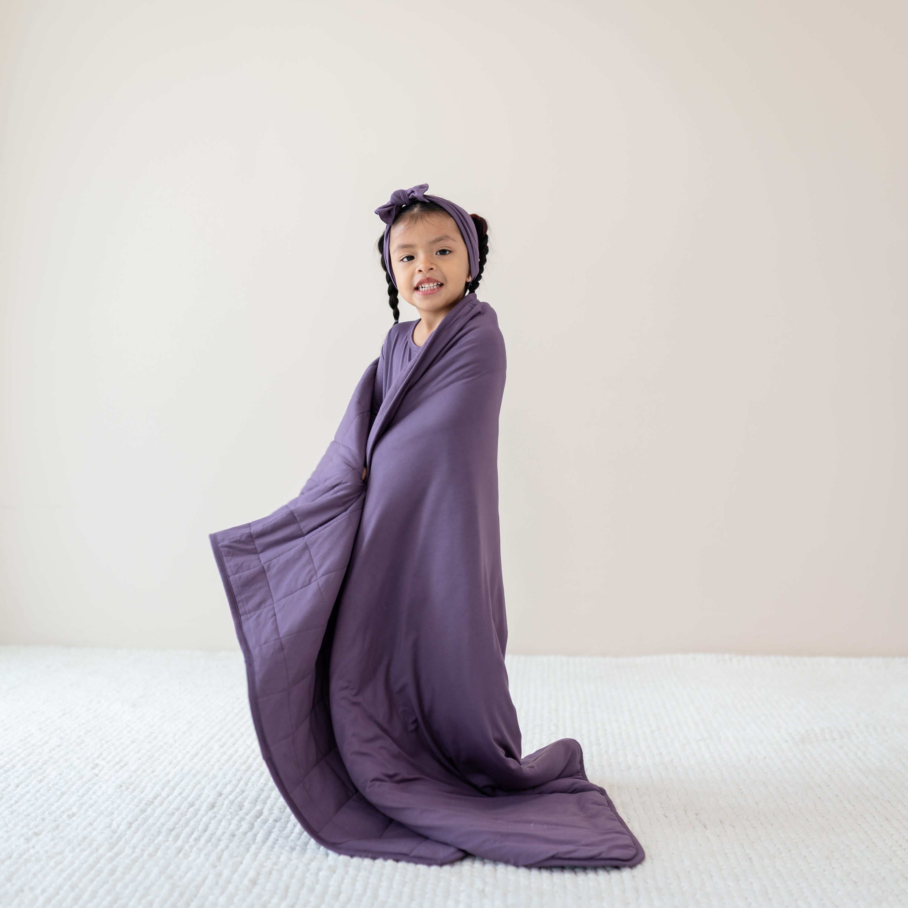 Child wrapped in Youth Blanket in Currant 2.5