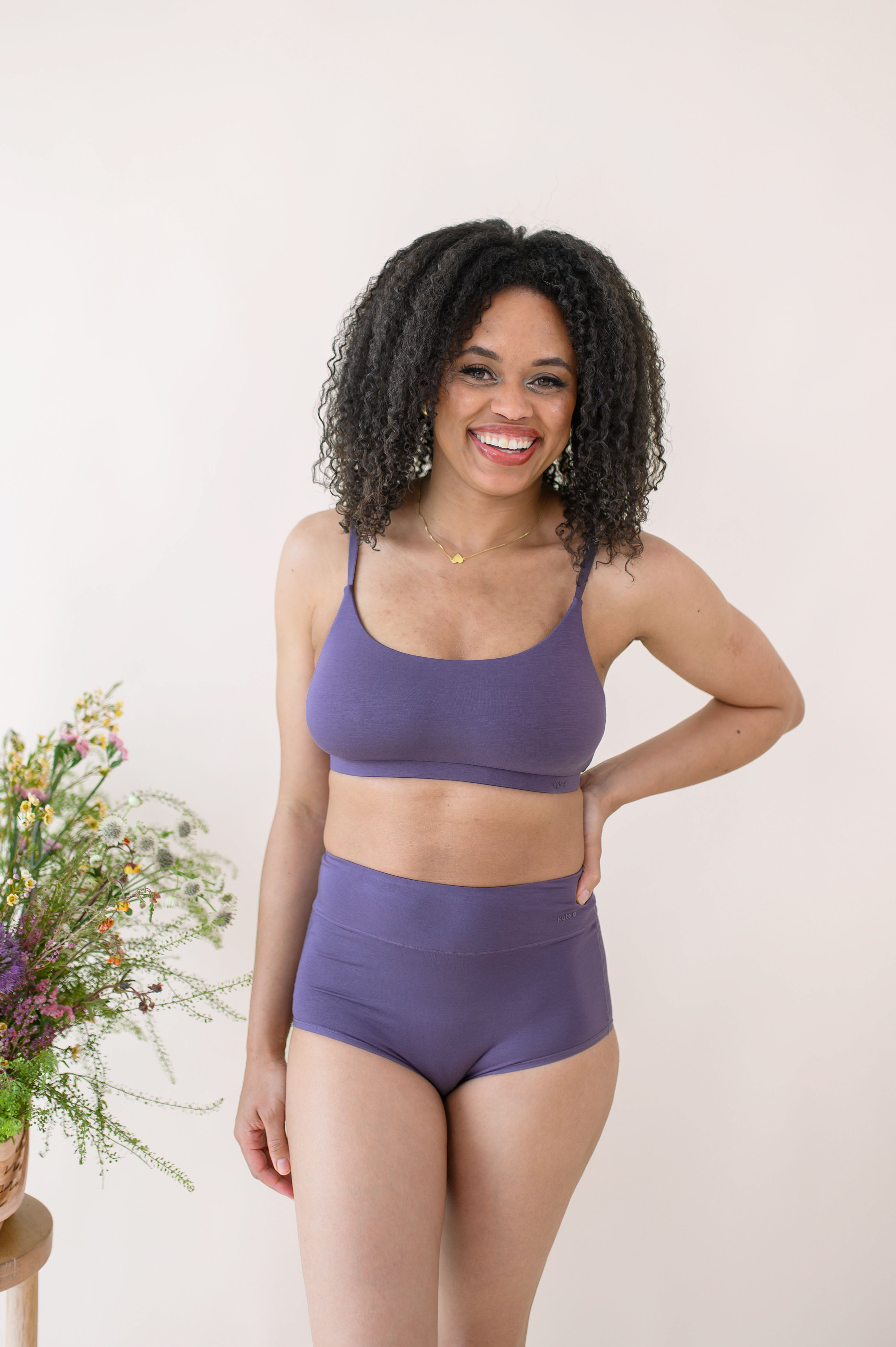 Smiling female modeling the Women's High-Waisted Brief in Currant with matching underwear