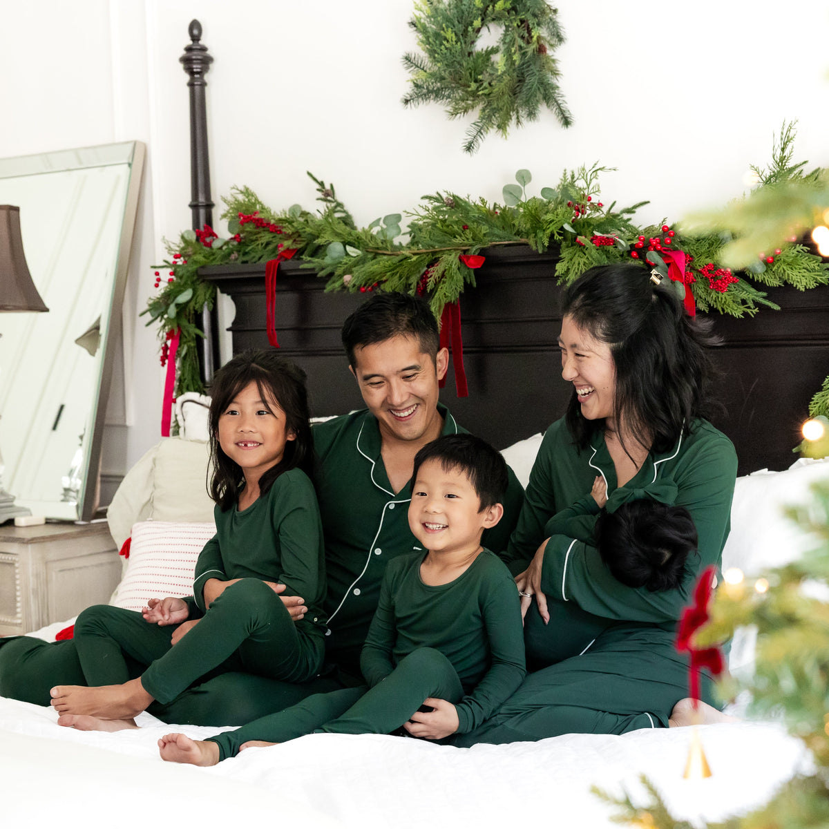 Family of 5 wearing matching dark green pajamas