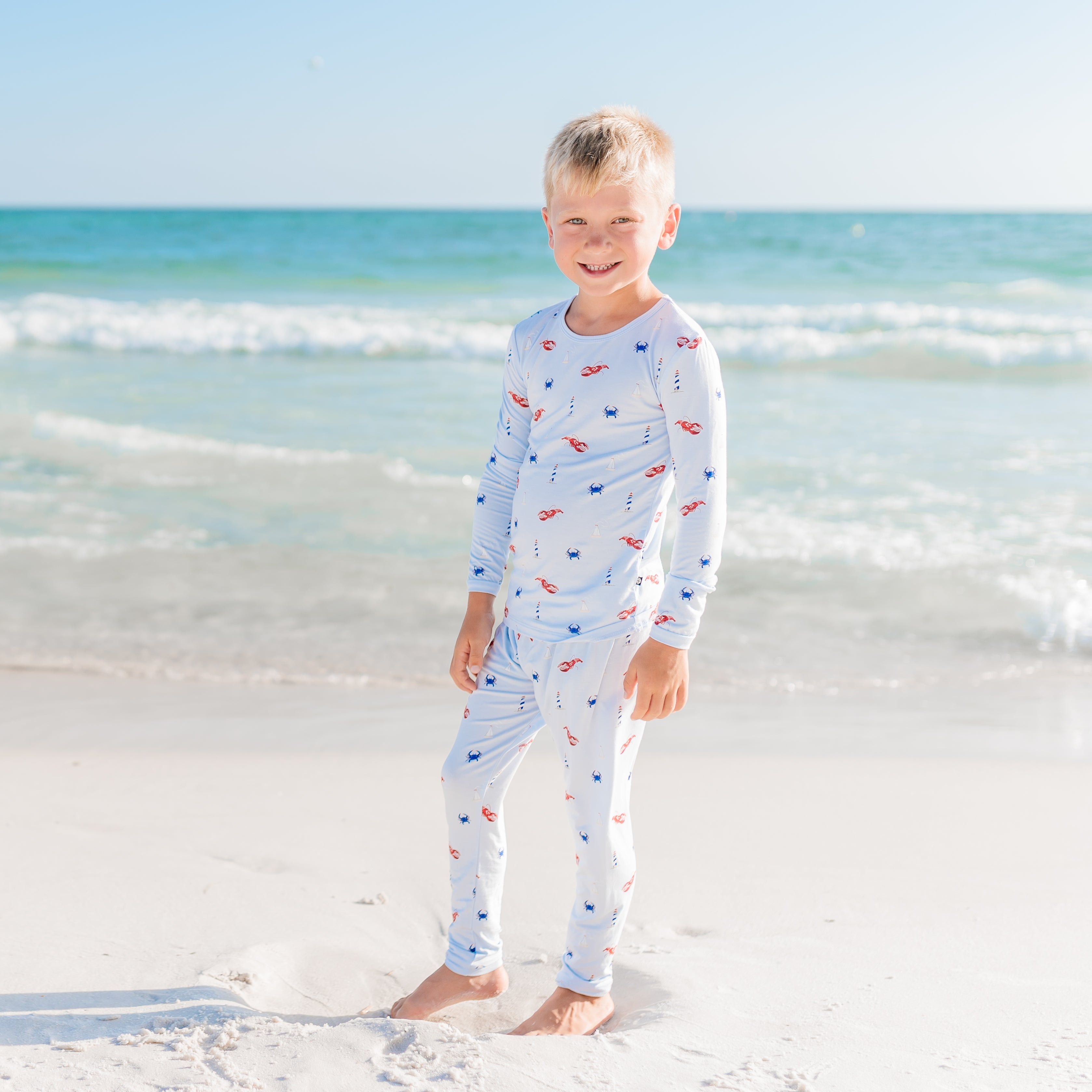 Child wearing a long-sleeve Harbor pajamas on a beach