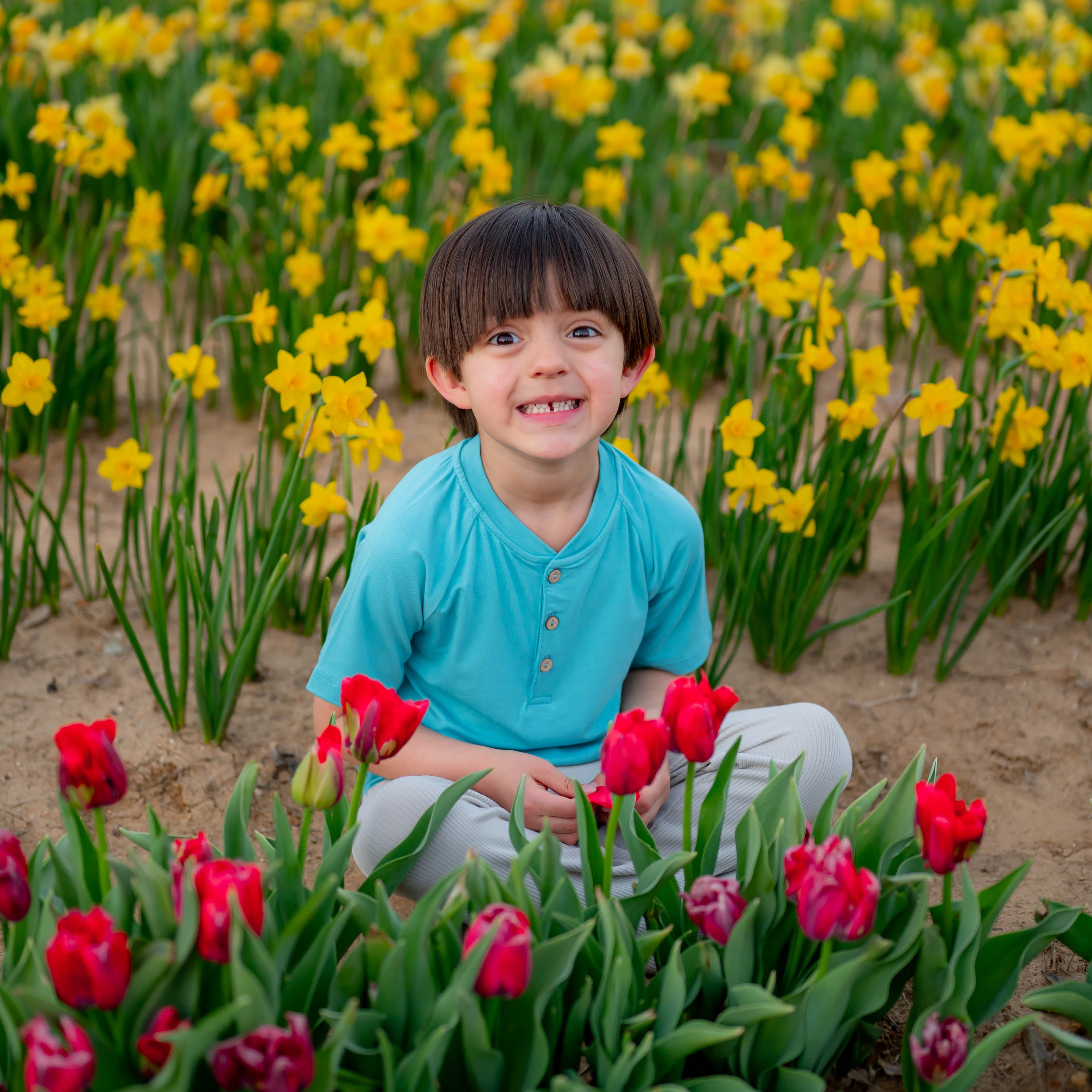 Toddler in Short Sleeve Toddler Henley Tee in Makai in tulip field