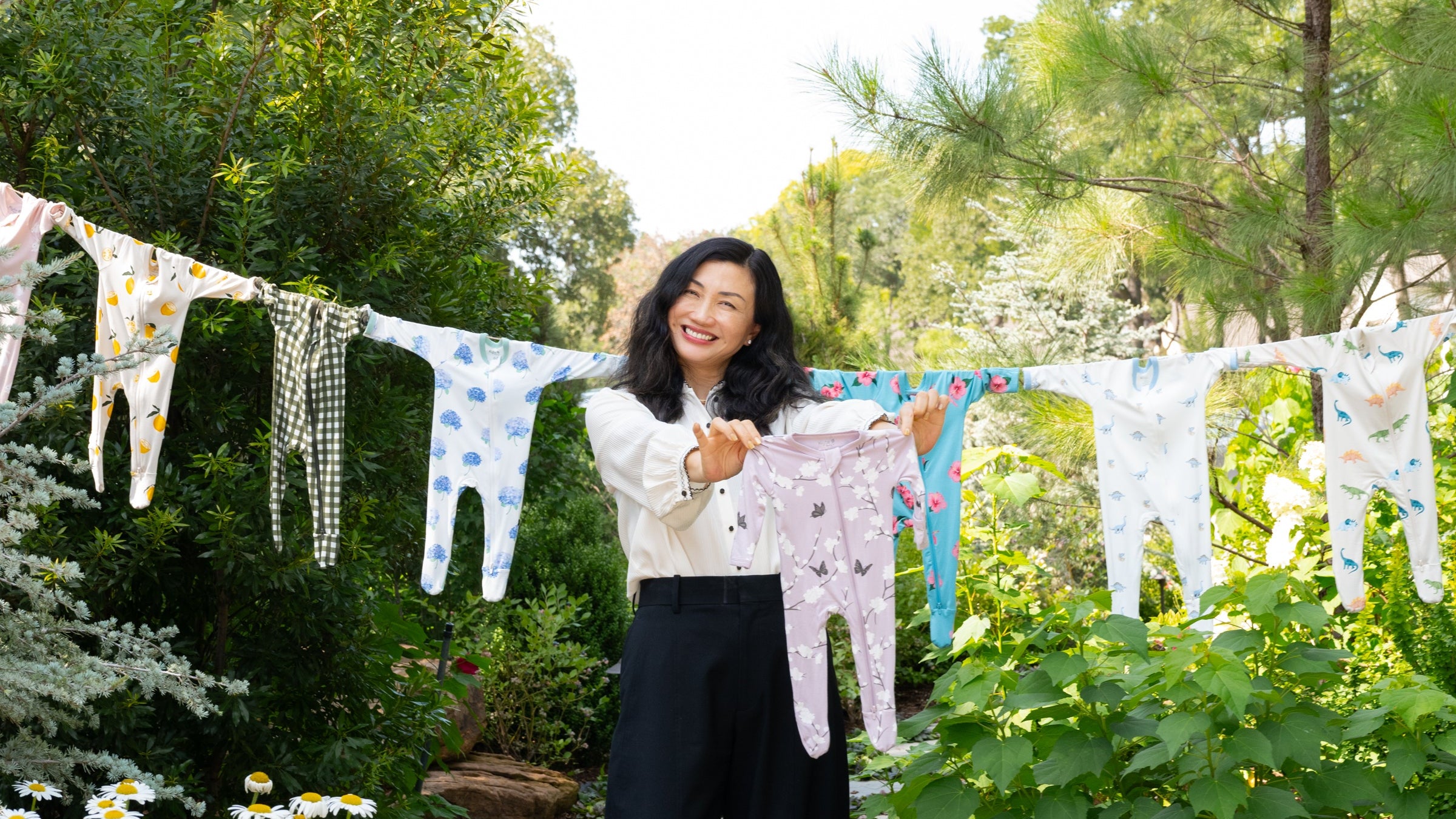 Woman standing in a garden with baby clothes hanging on a line
