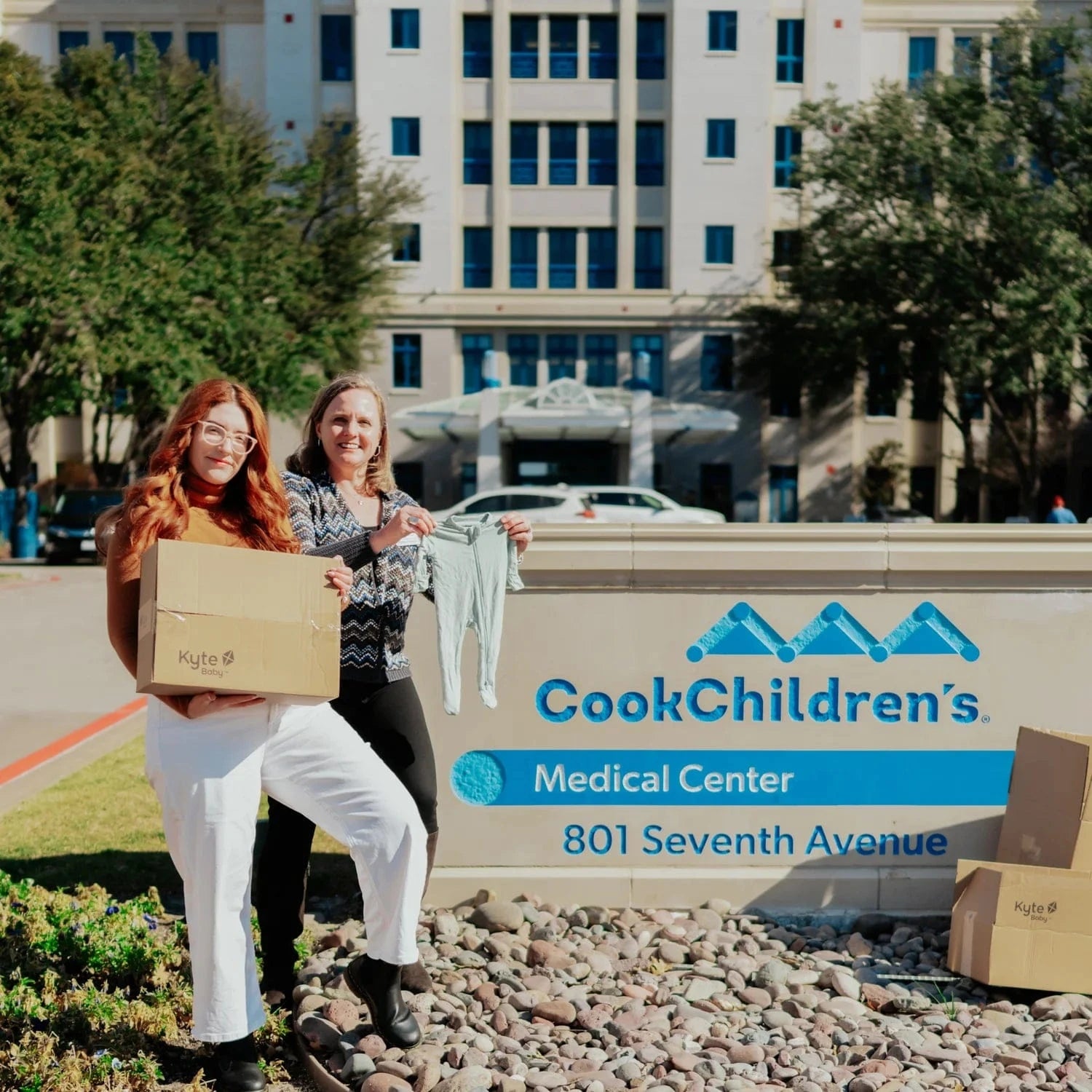 Kyte Baby staff showing donation box in front of Cook Children's Hospital