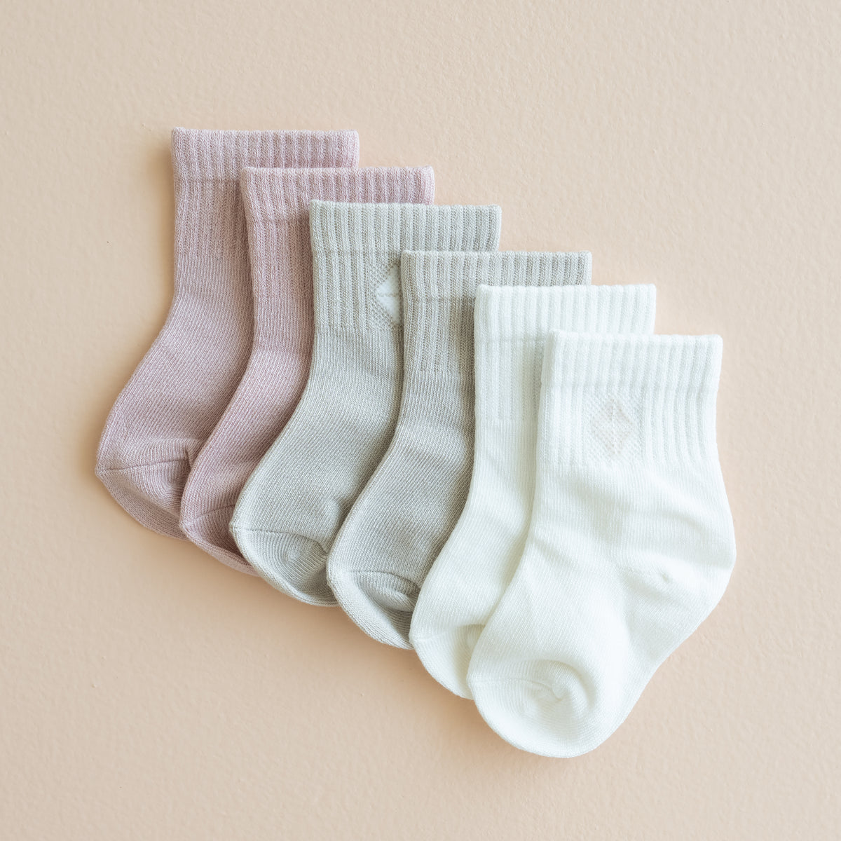 Flat lay of the Crew Socks Combo 3-Pack in Pastel shown in the colors Blush, Oat and Cloud