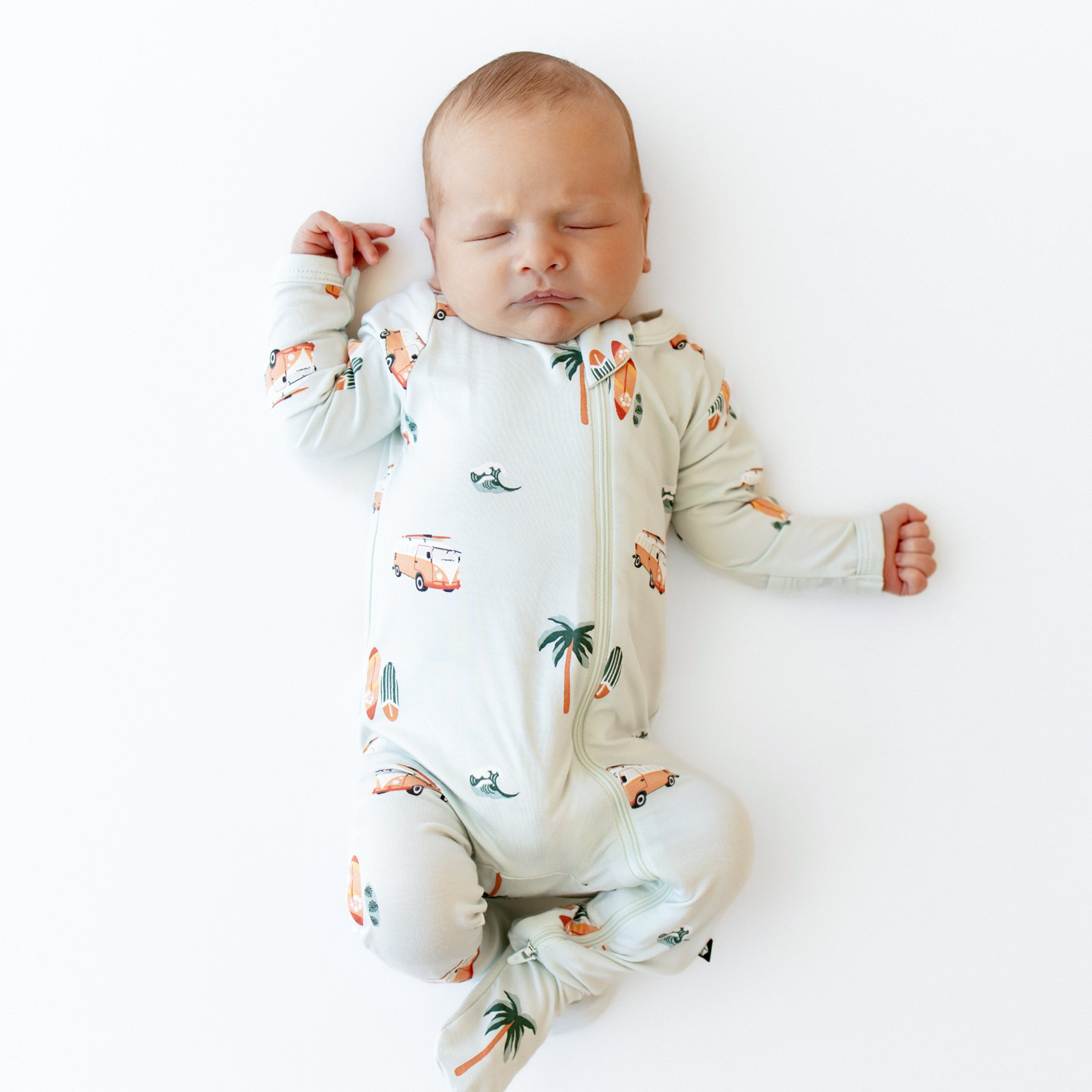 Sleeping baby wearing the Zippered Footie in Dew Surf