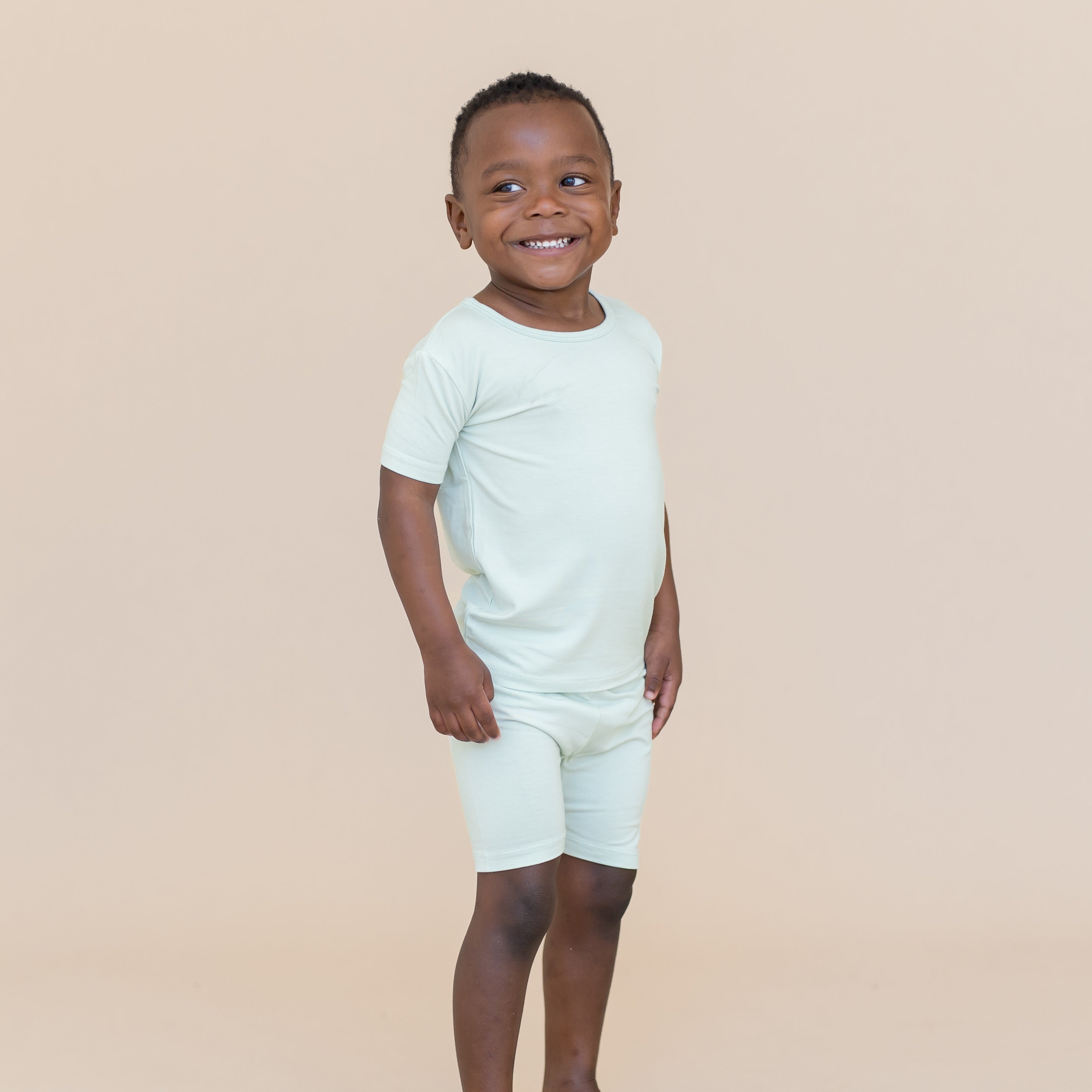 Young boy wearing a light blue-green short sleeve pajama set