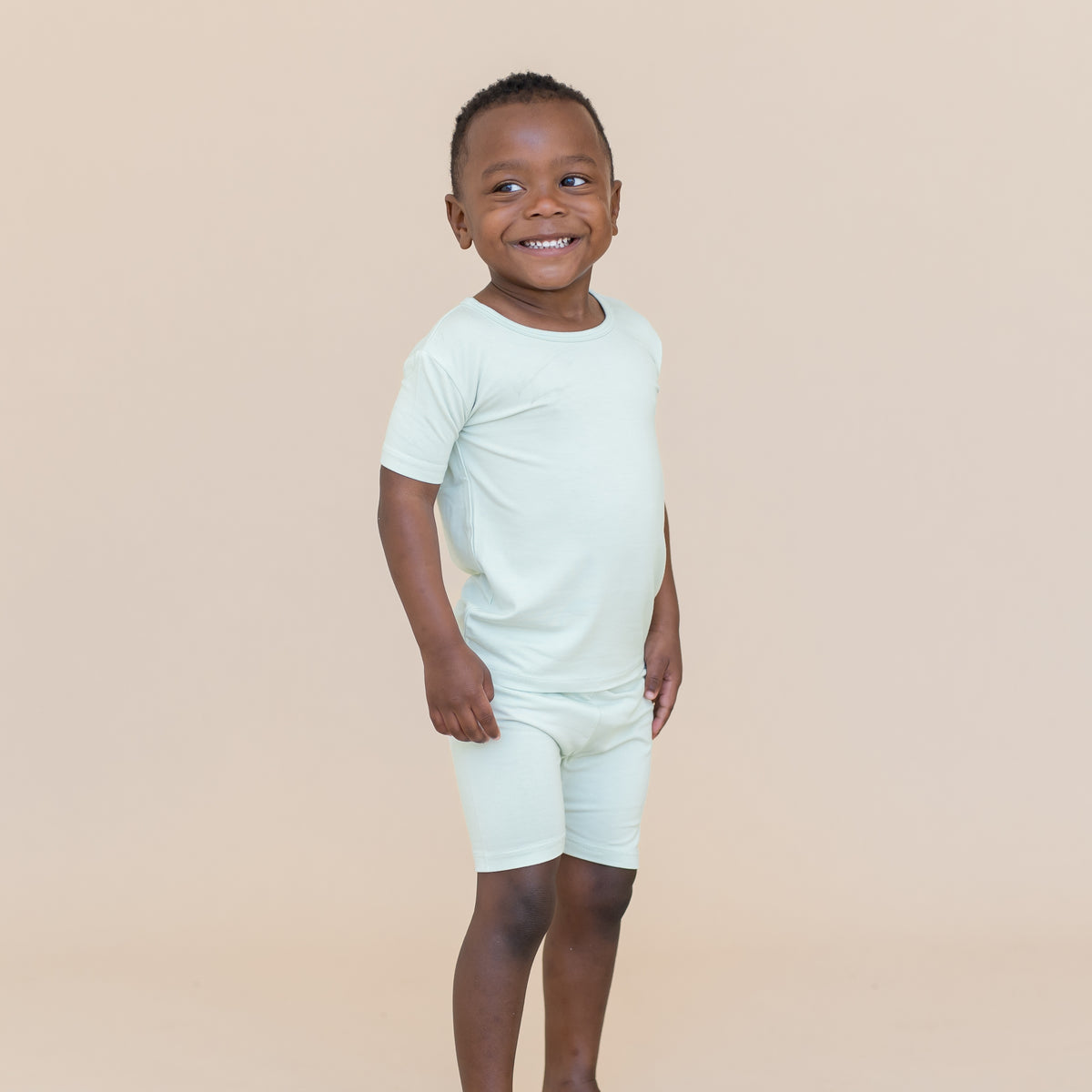 Young boy wearing a light blue-green short sleeve pajama set