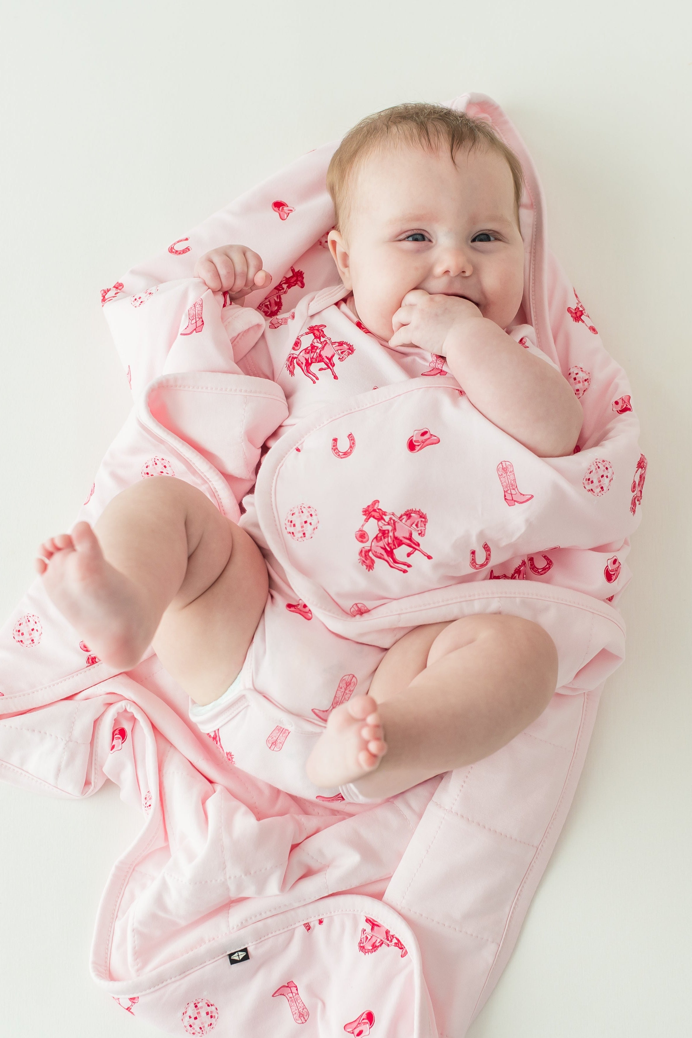 Infant girl laying wrapped in a Baby Blanket in Disco Cowgirl wearing a matching short sleeve bodysuit