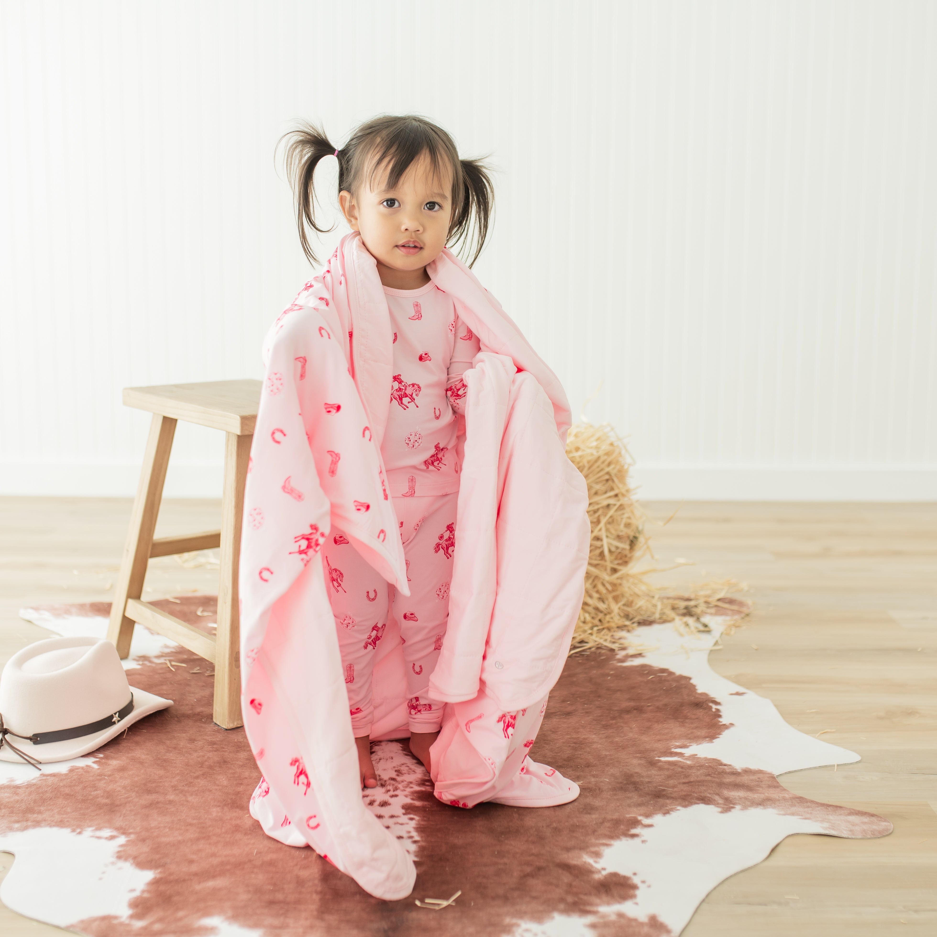 Young toddler standing with the Toddler Blanket in Disco Cowgirl 1.0 over her shoulders