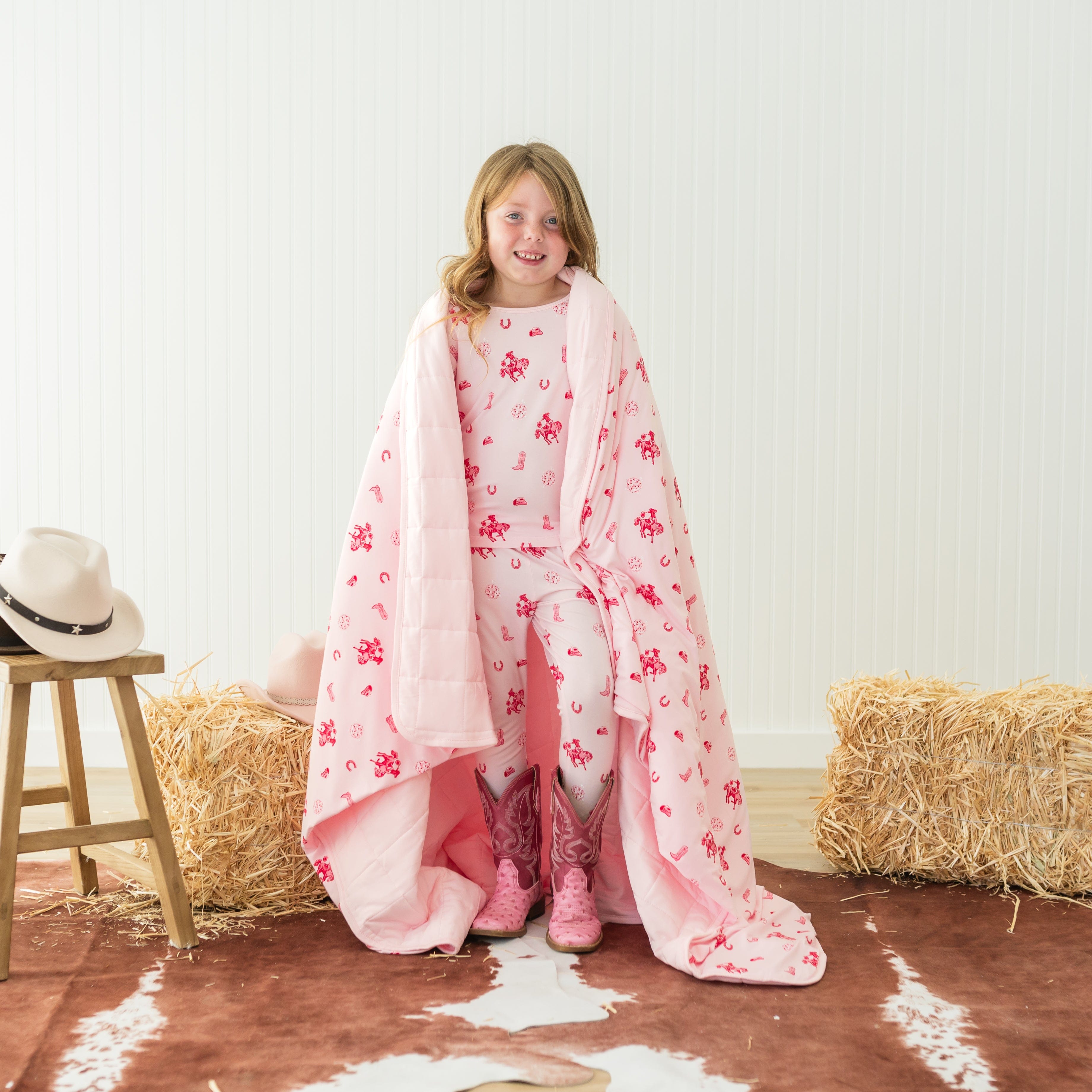 Young girl standing with the Youth Blanket in Disco Cowgirl 2.5 wrapped around her shoulders wearing matching toddler pajamas