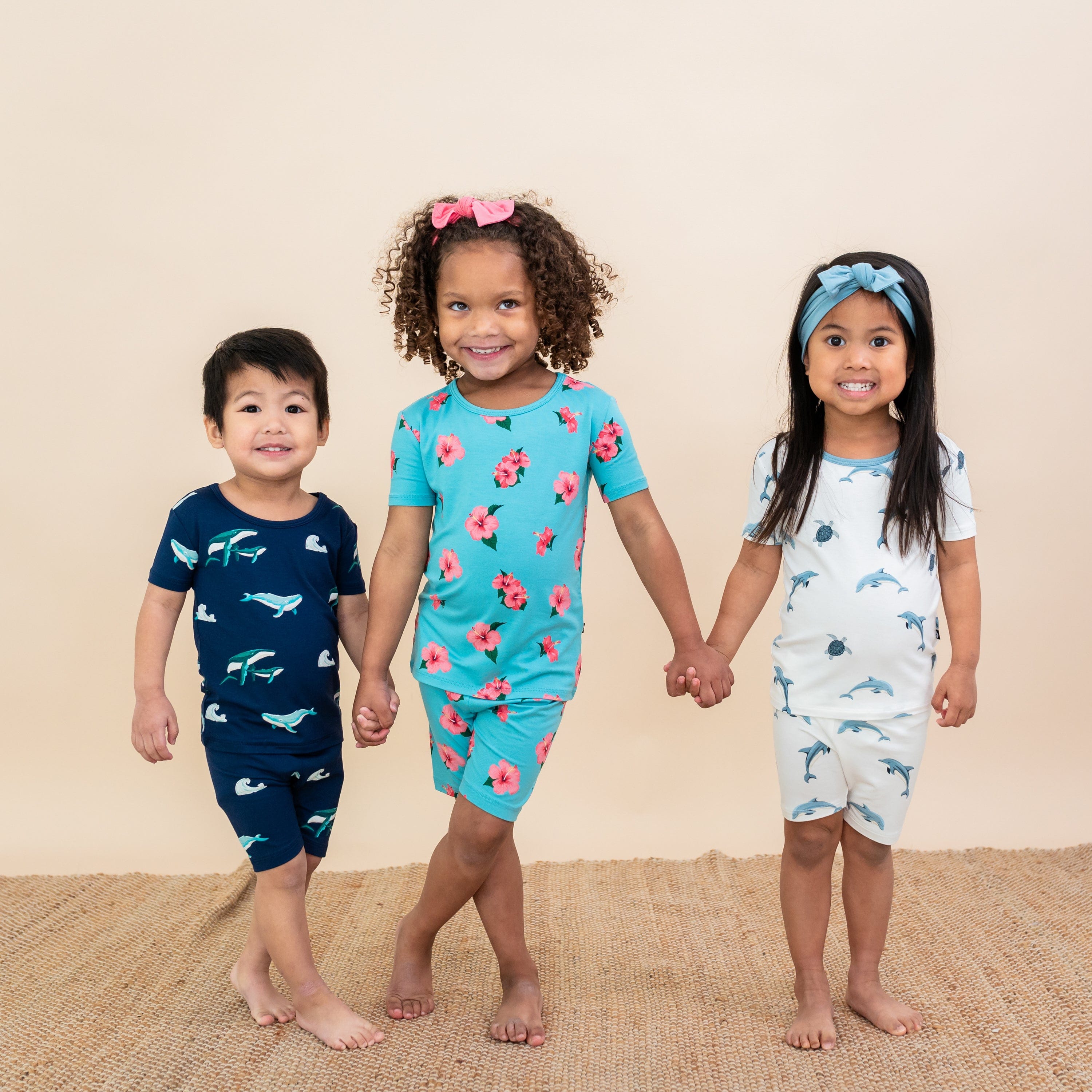 Three Kids wearing Short Sleeve Pajamas from Kyte Baby in Hawaiian inspired collection