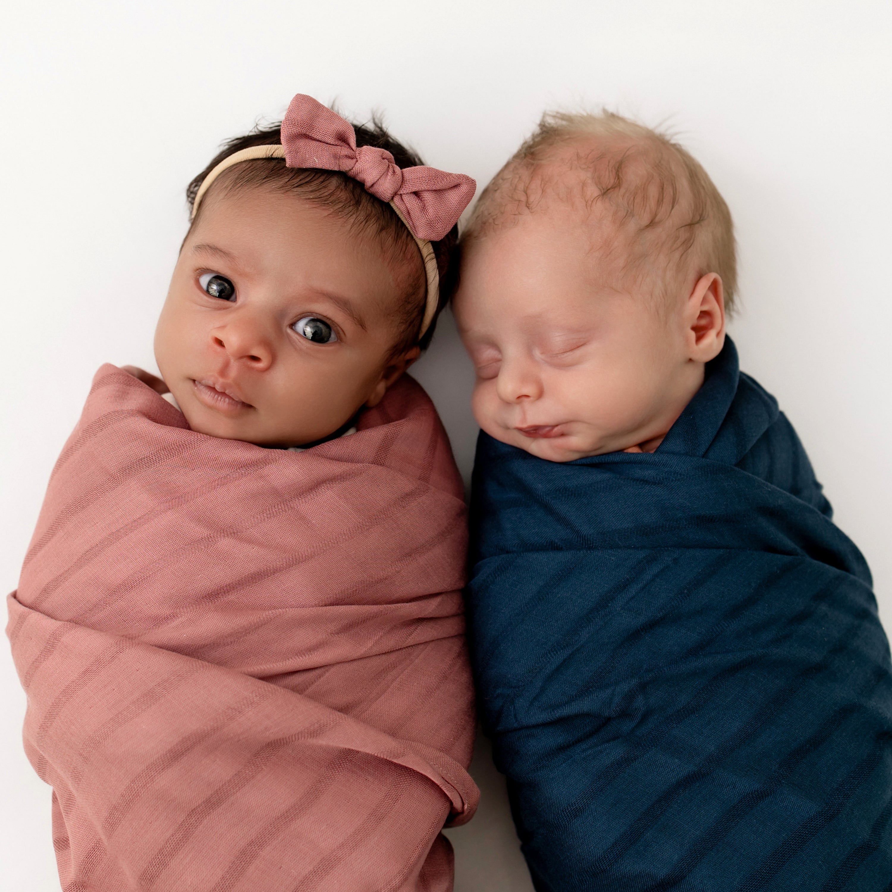 Babies wrapped in swaddling blankets and one wearing Bamboo Muslin Tiny Bow in Dusty Rose